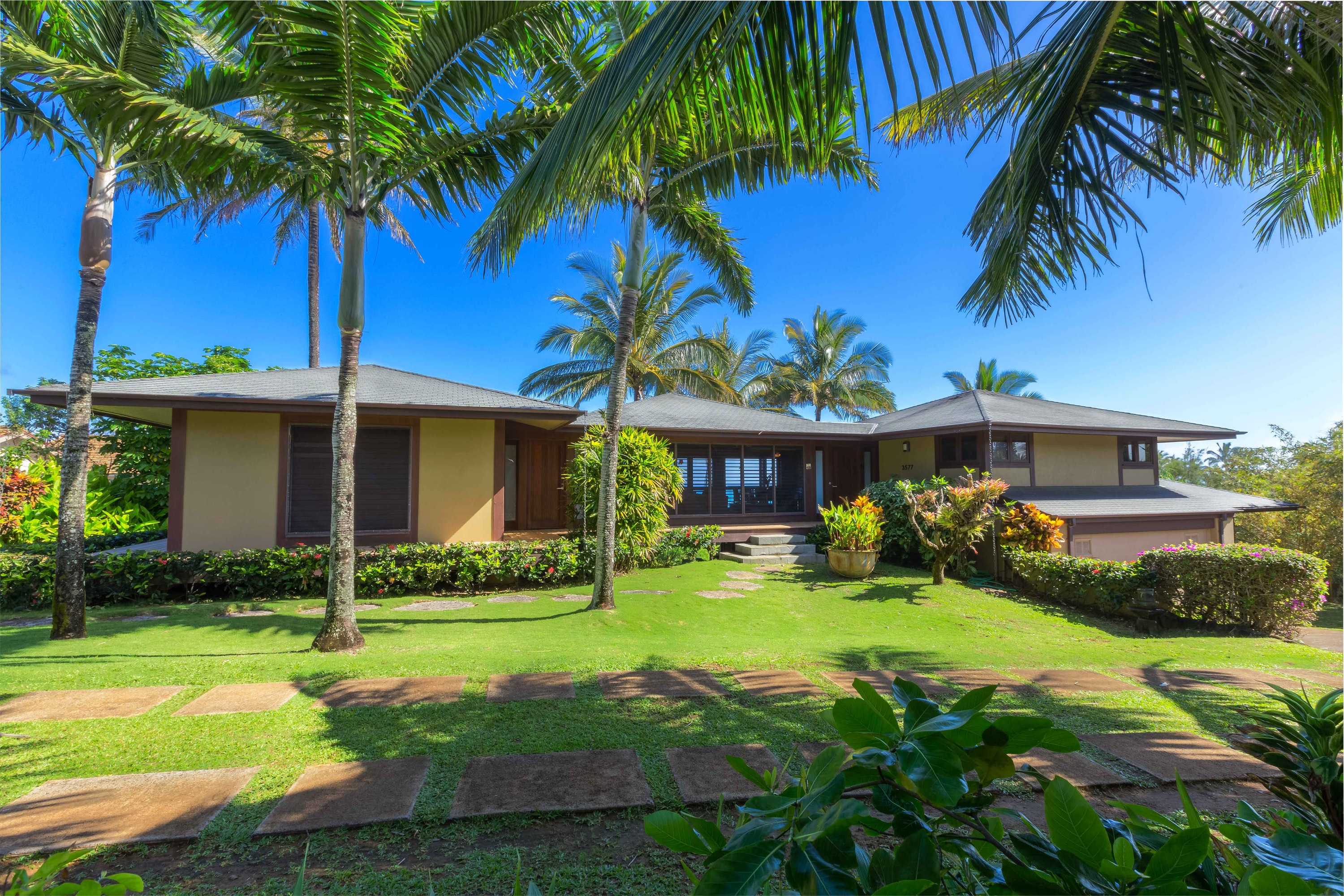 Beach house rental exterior and lawn with palm trees