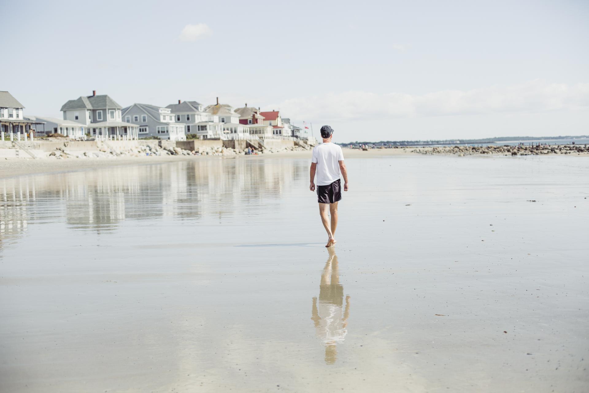Man walking on the coast in Maine.