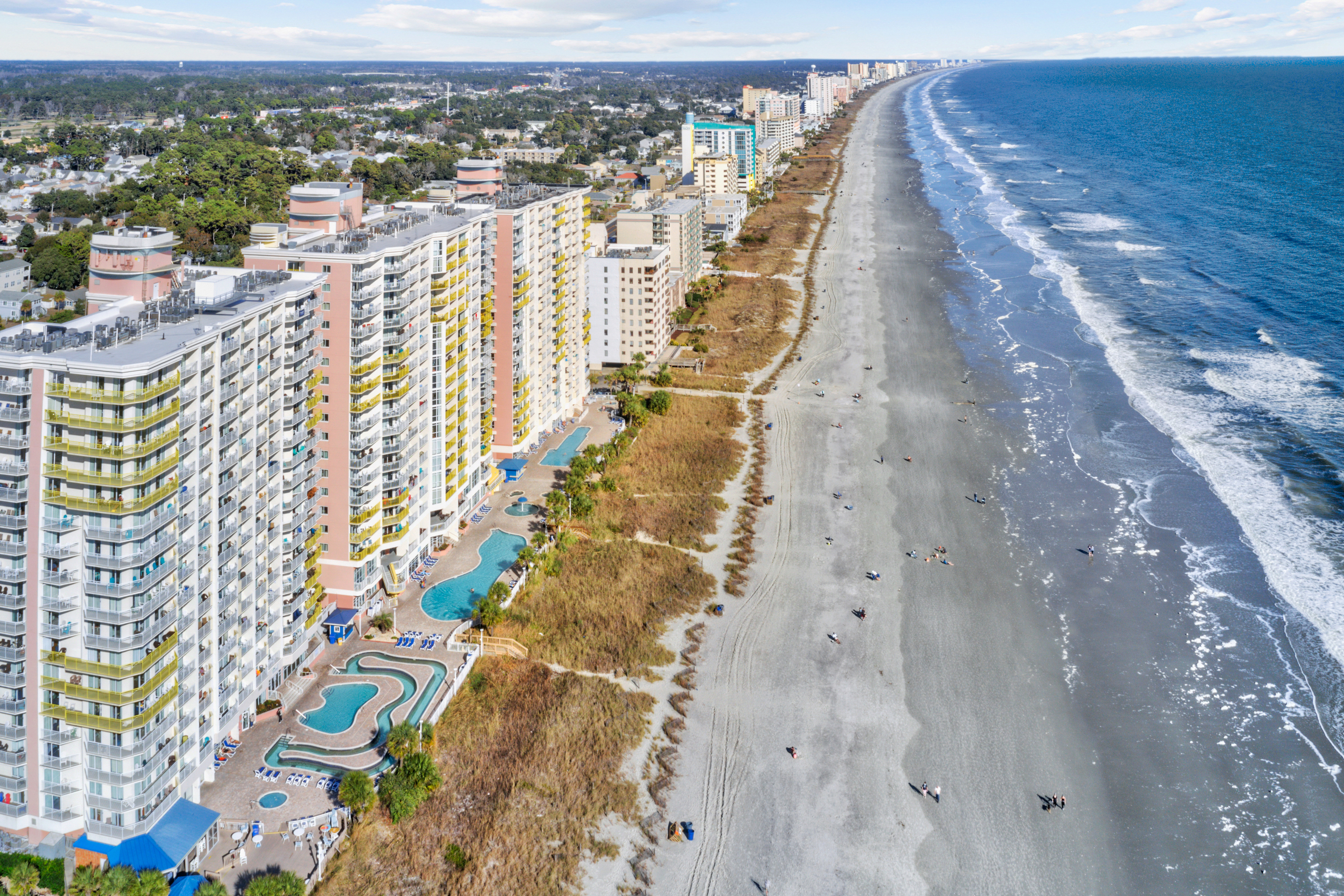 A drone shot of the coastline surrounded by hotels in Myrtle Beach, SC.