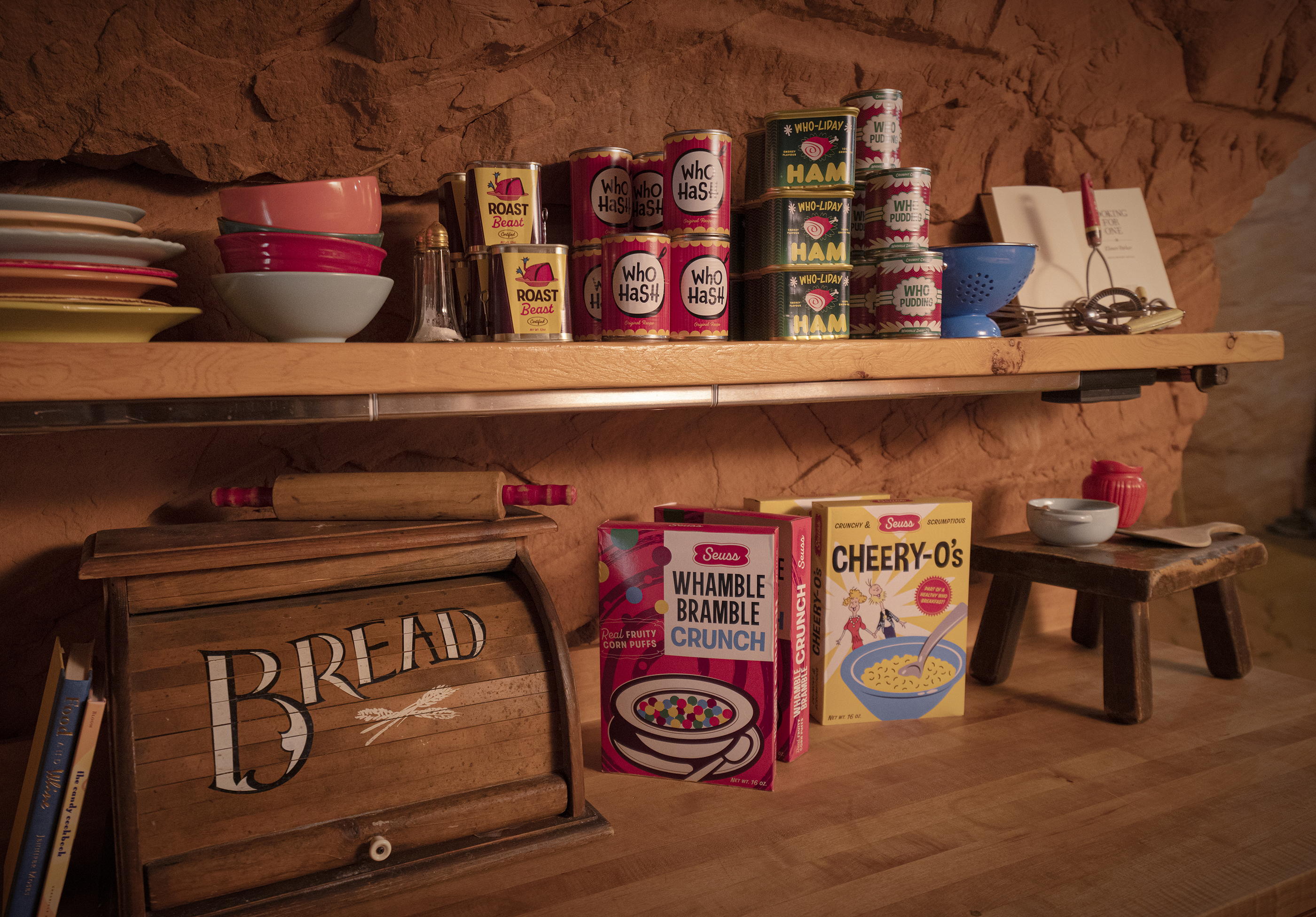 a bread box, cereal boxes and more food stock the shelves of the grinch's kitchen