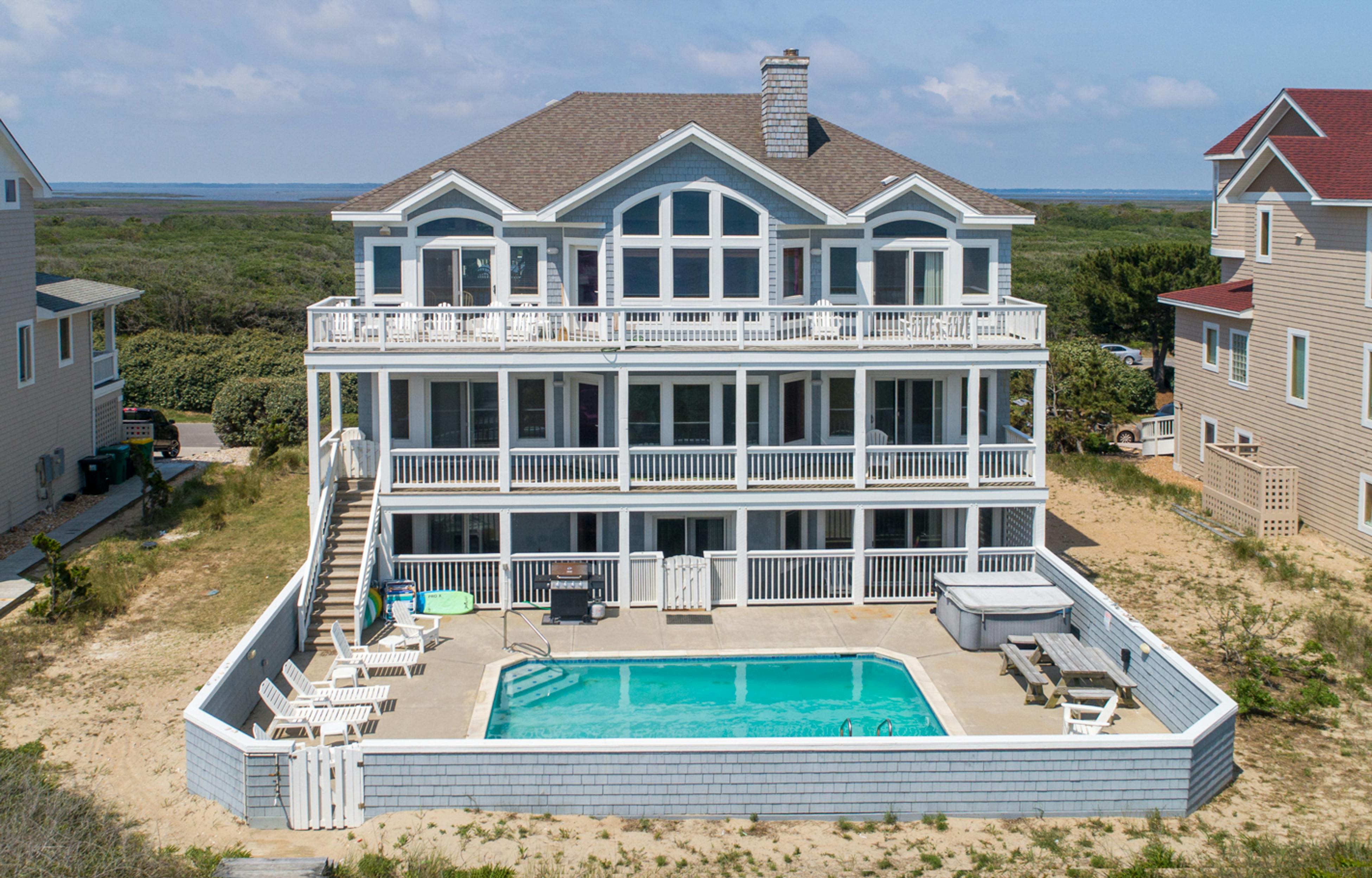 Three story vacation home rental in Outer Banks, NC with an outdoor pool, hot tub and pool amenities.