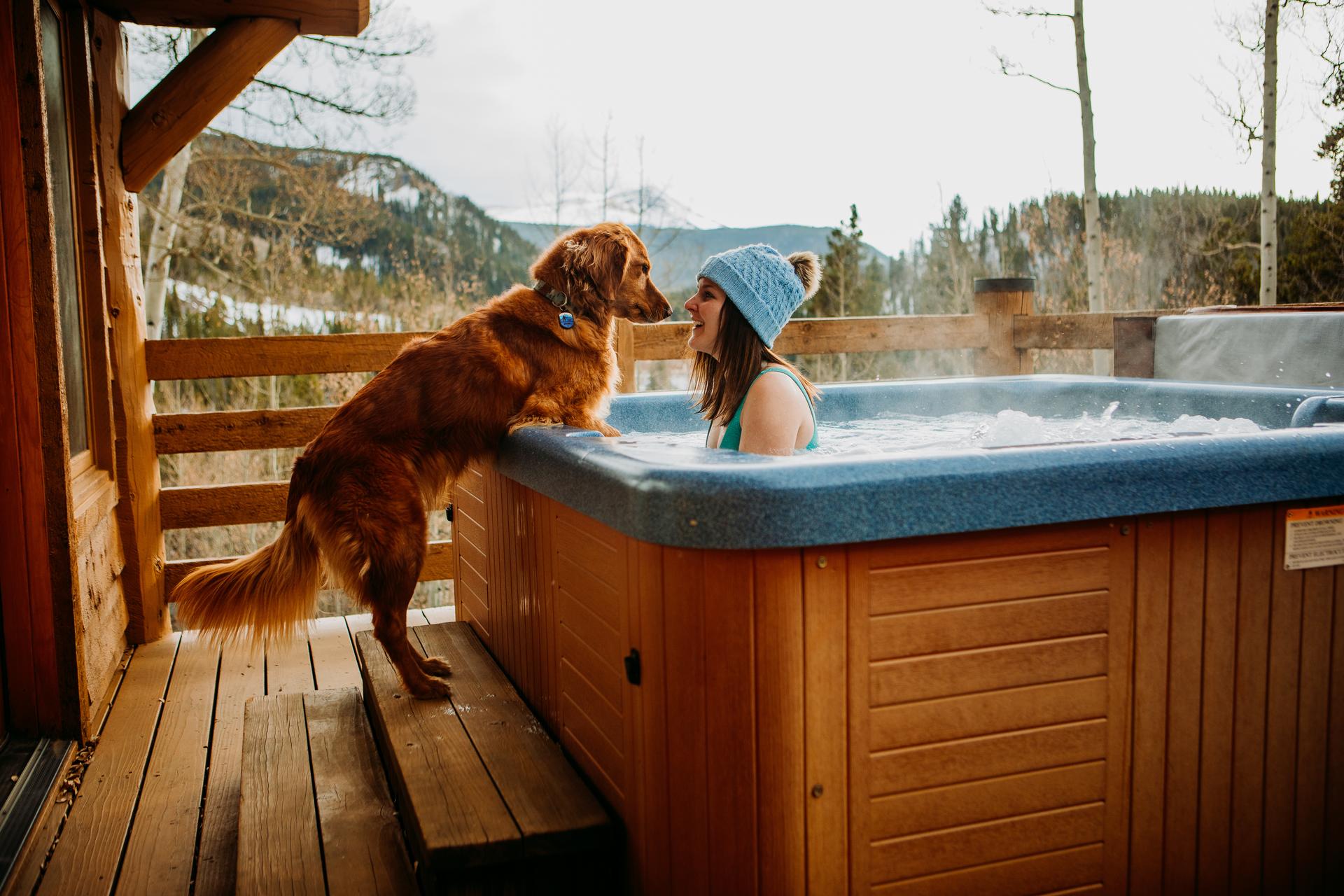Golden Retriever jumps on the side of a hot tub to kiss owner