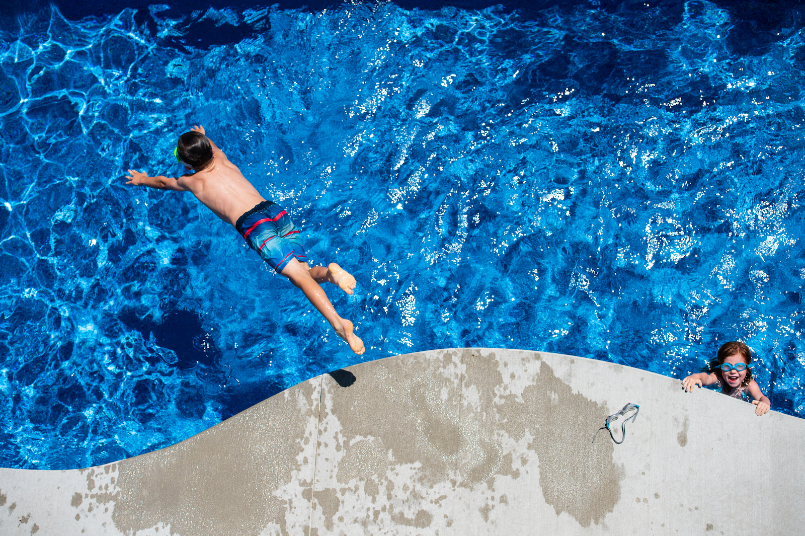 Image of kid jumping into a pool.
