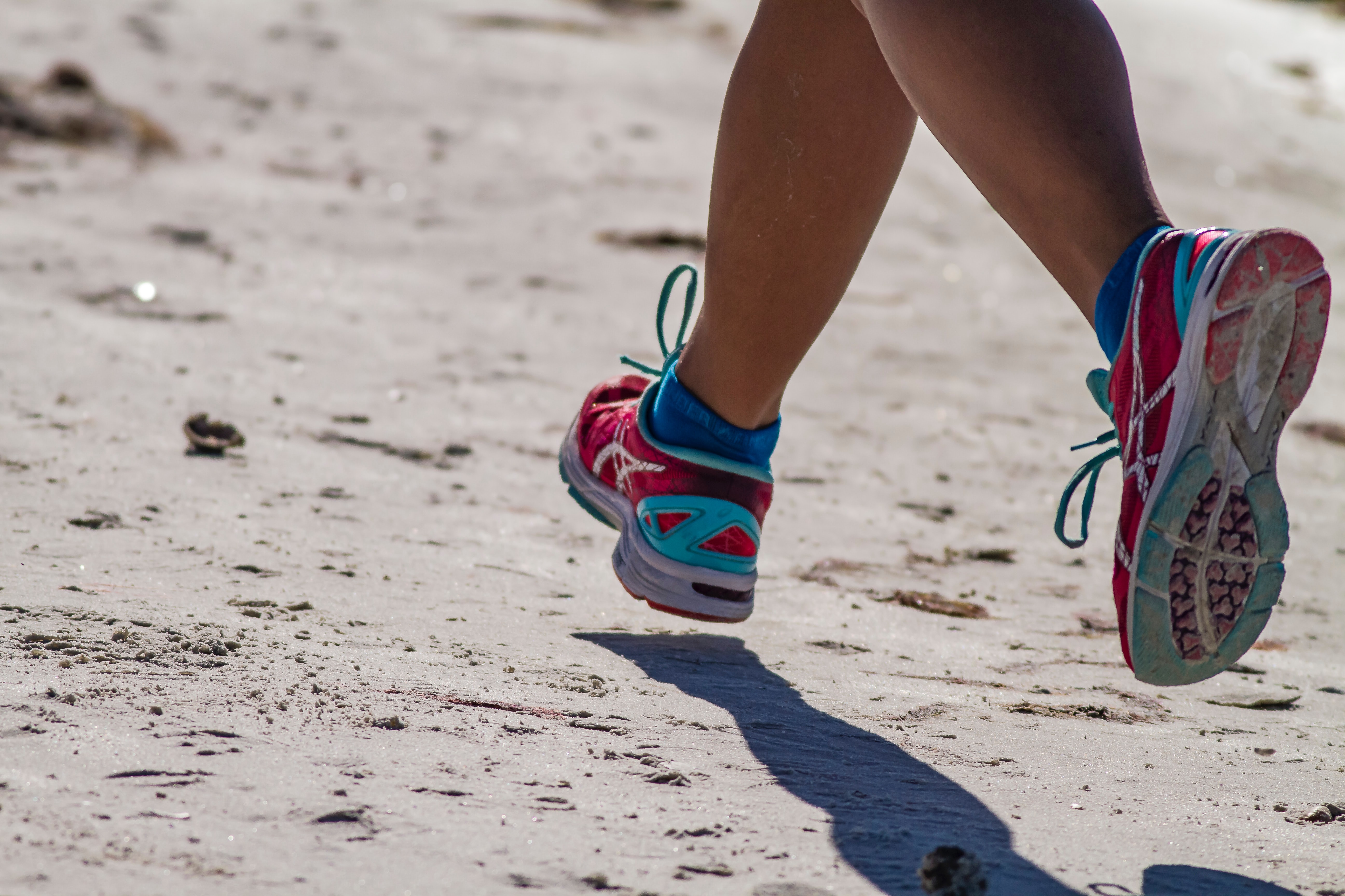 Child's feet running on the beach.