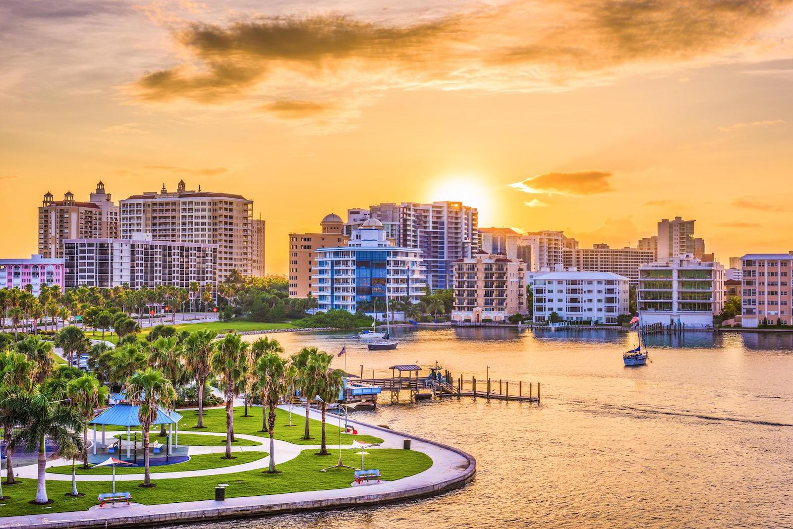 Drone shot overlooking a park, the Sarasota skyline, and the water with boats.