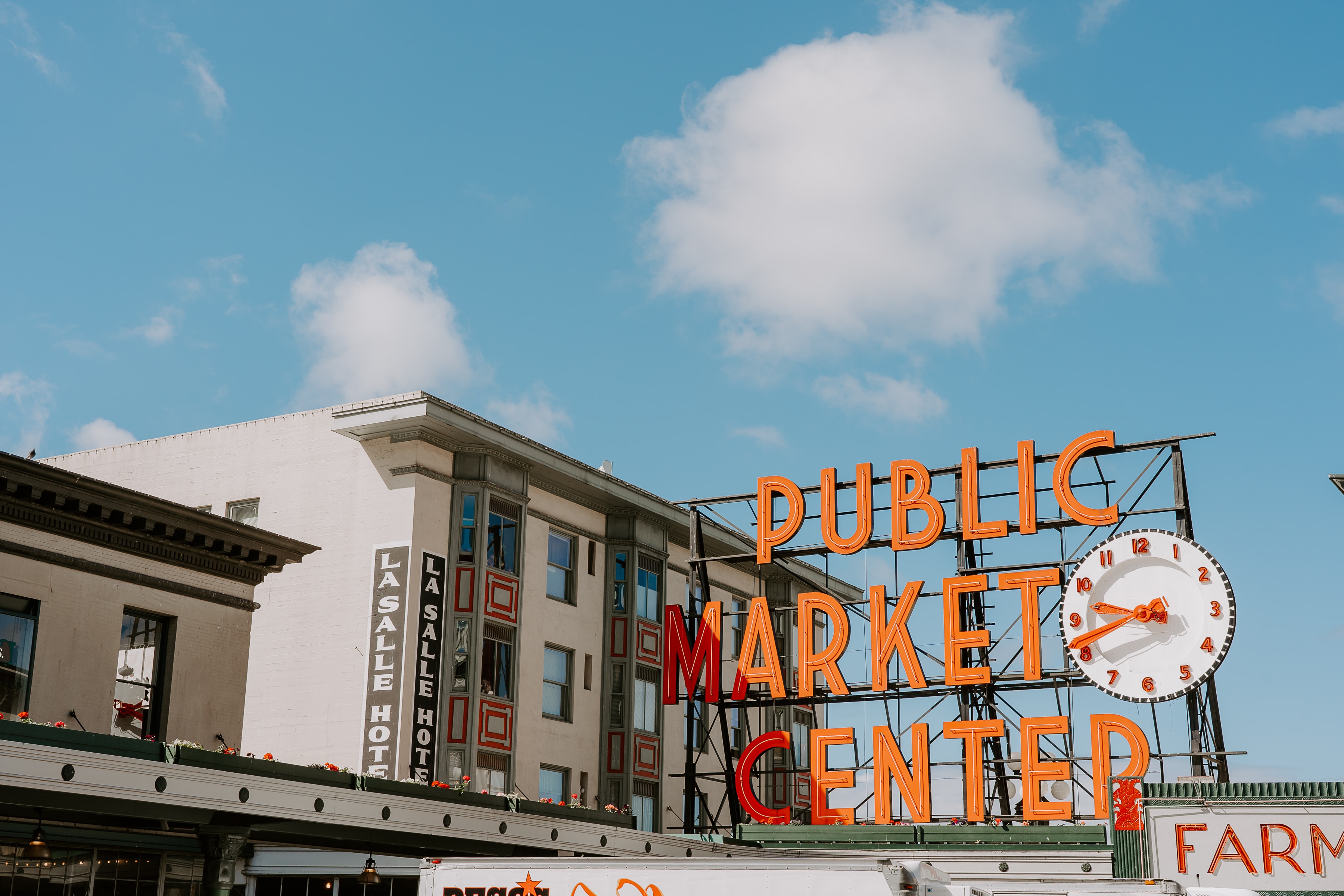 Hotel building near a giant sign that says "Public Market Center" with a clock.