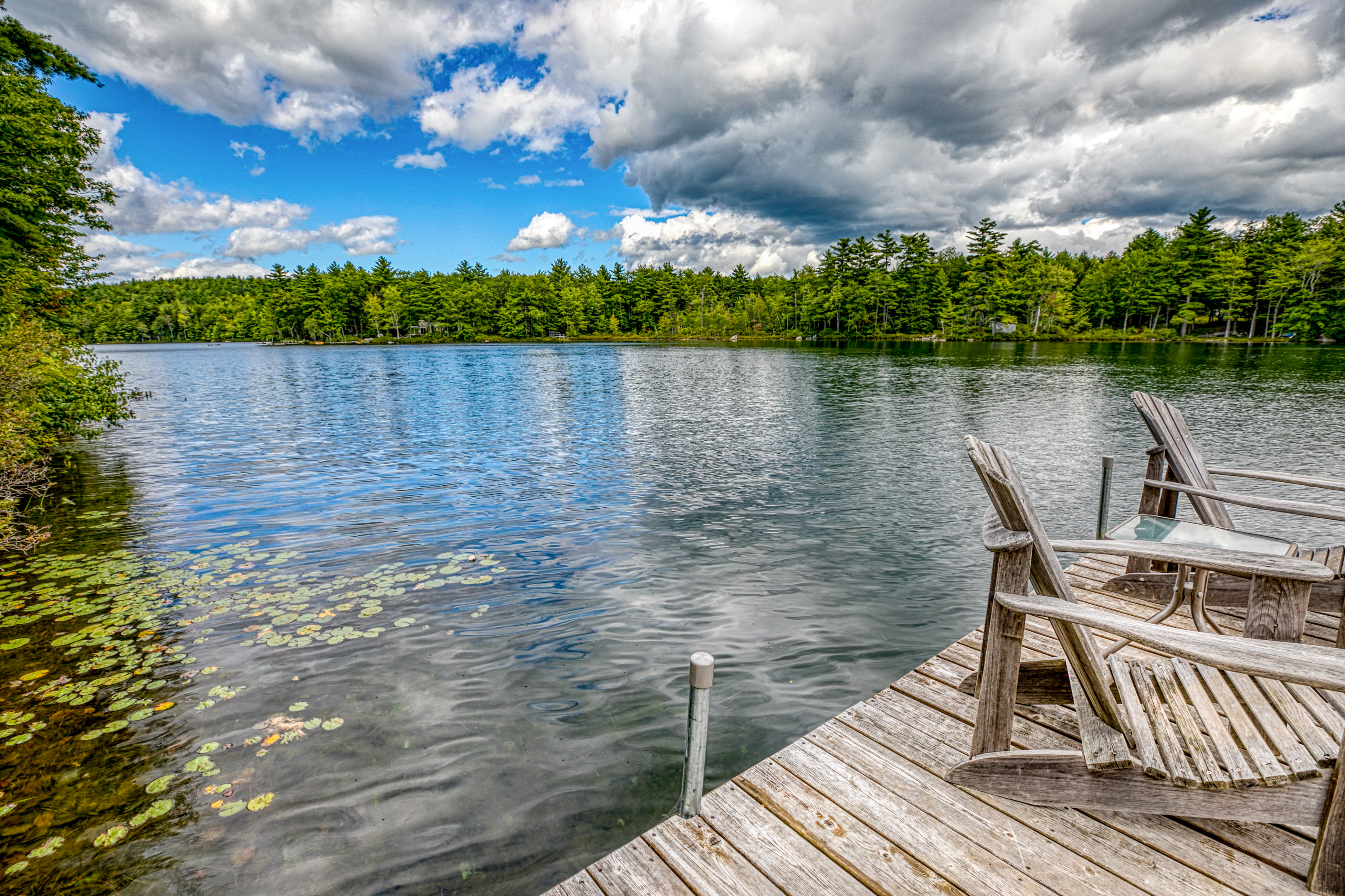 Wooden water dock with adirondack chairs at Sebago Lake, ME