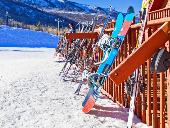 snowboards leaning up against a railing on the mountain