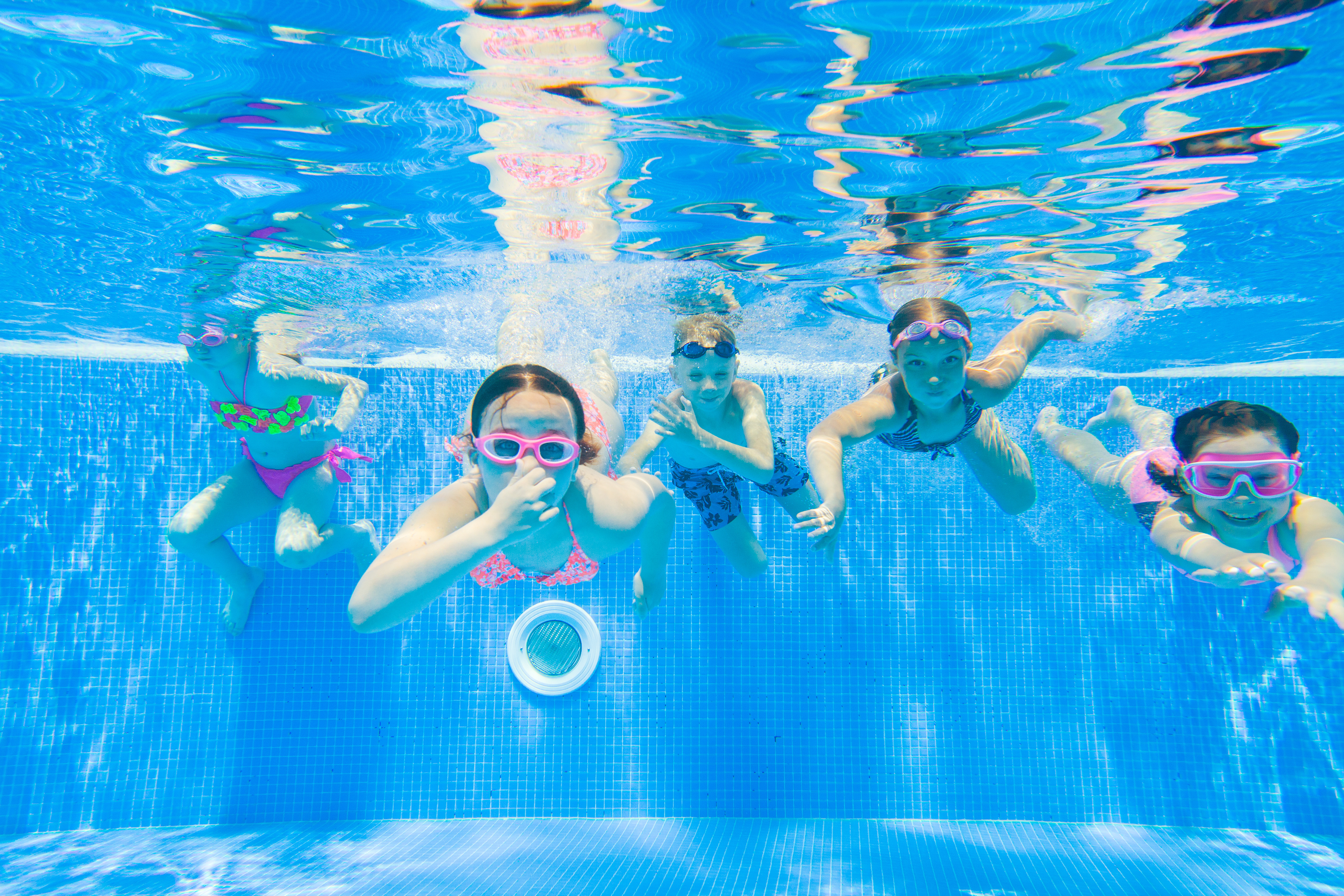 kids swim underwater in a TOPSL resort pool