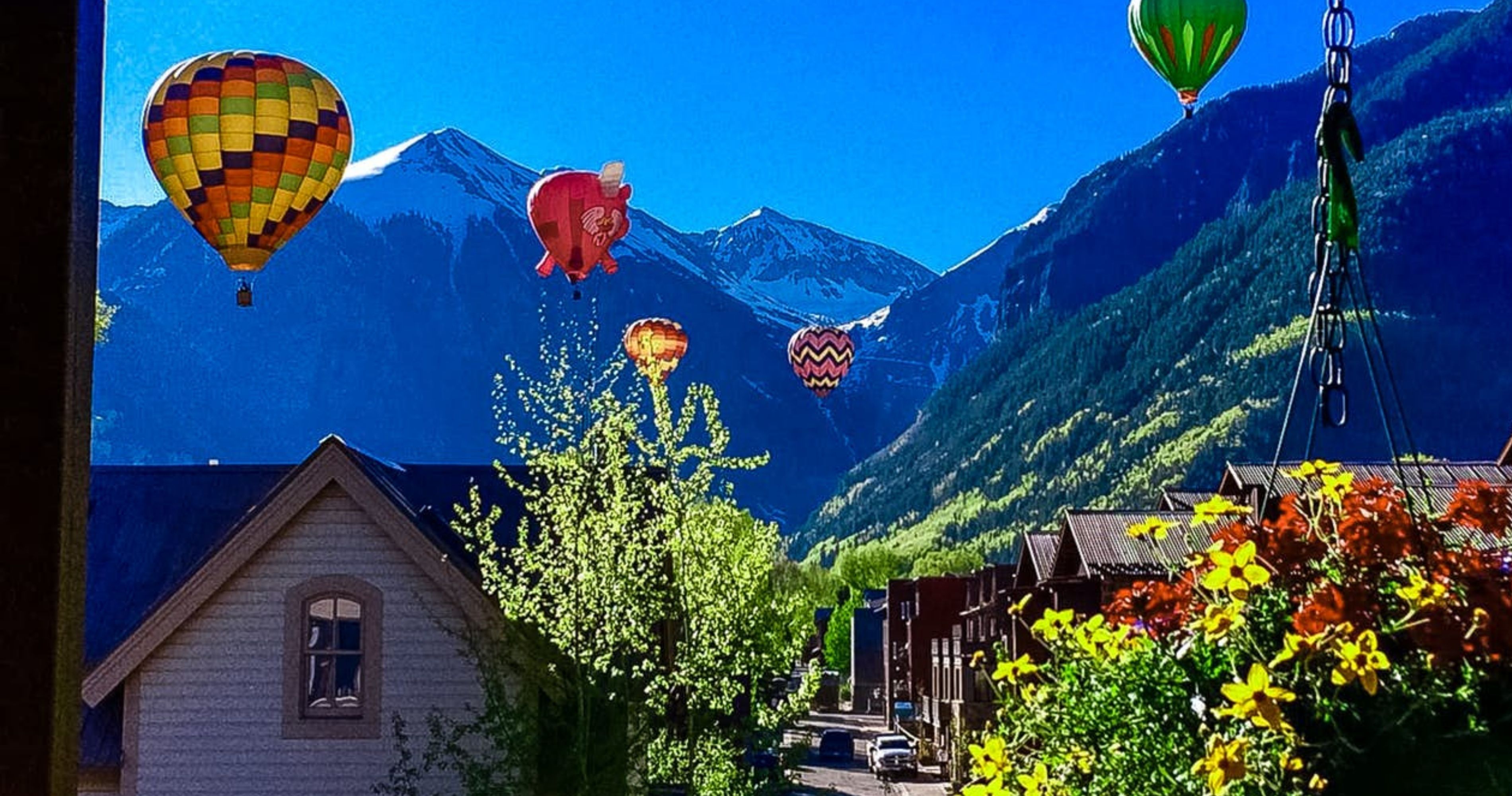 Hot air balloons rising in the air seen from a vacation home in Telluride, CO.