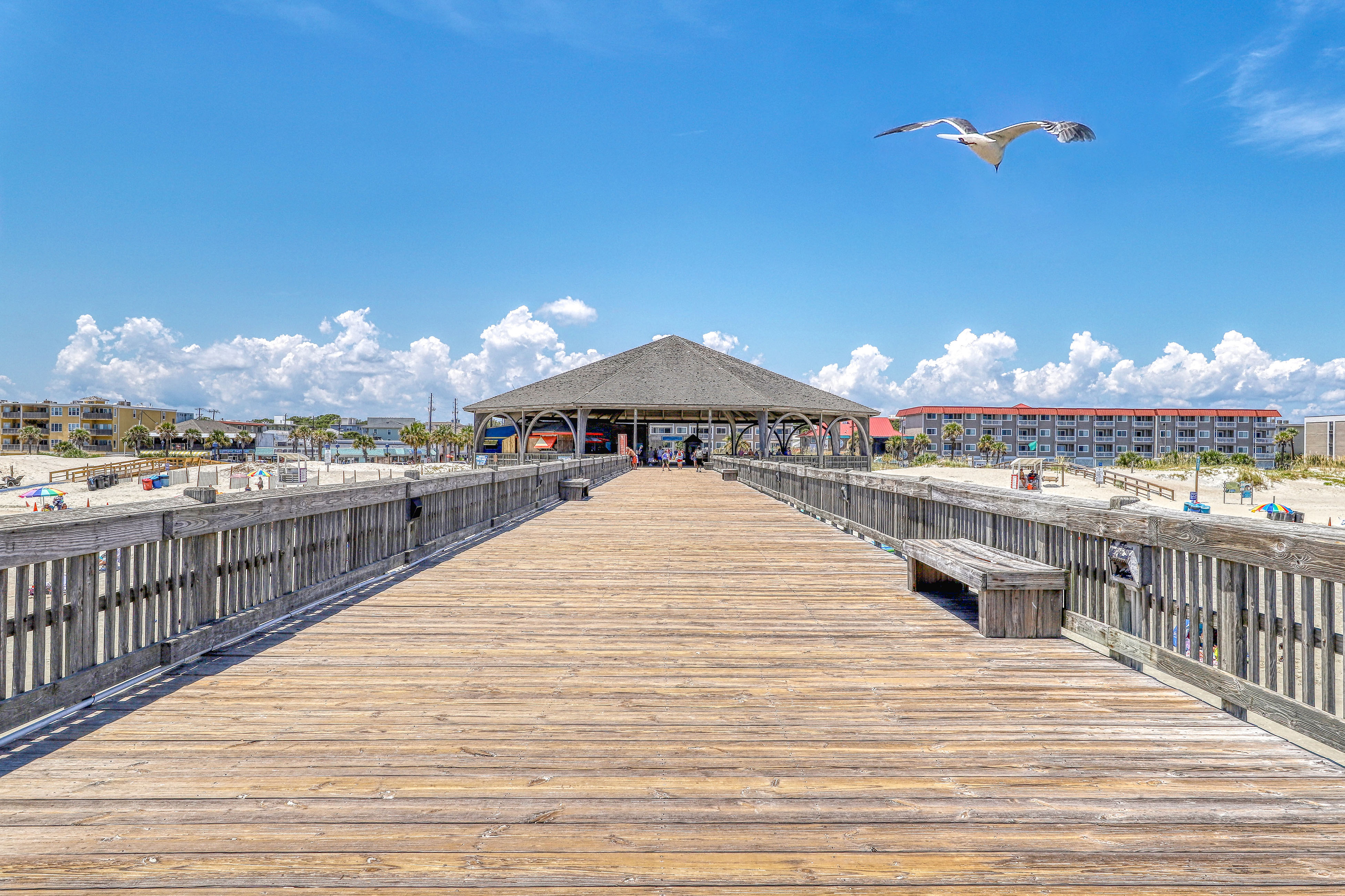Large wooden pier at a sandy beach in Tybee Island, GA.