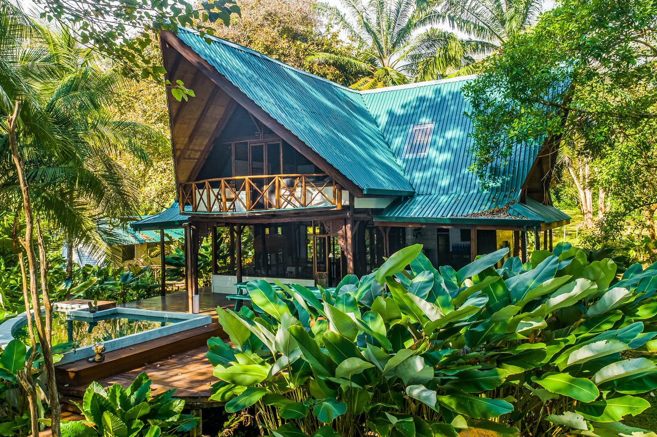 Villa vacation rental in Costa Rica with an outdoor pool surrounded by rain forest trees.