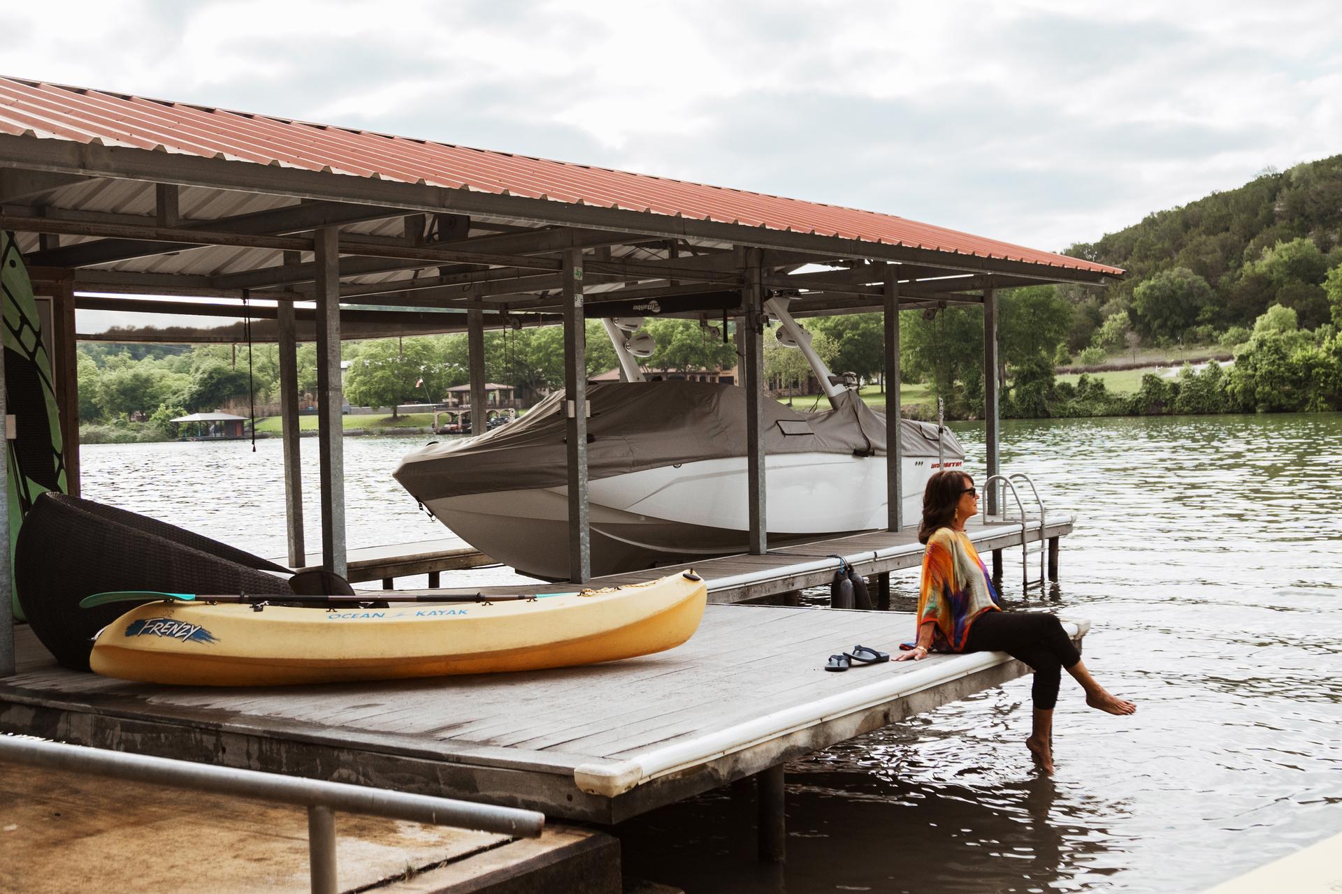 vacasa homeowner diana sits on her dock outside her vacation home