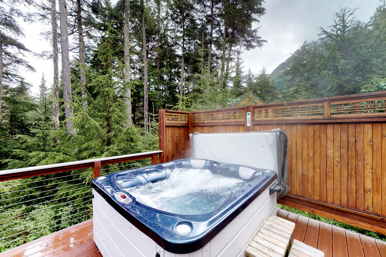 a bubbling hot tub on a deck with the forest in the backdrop