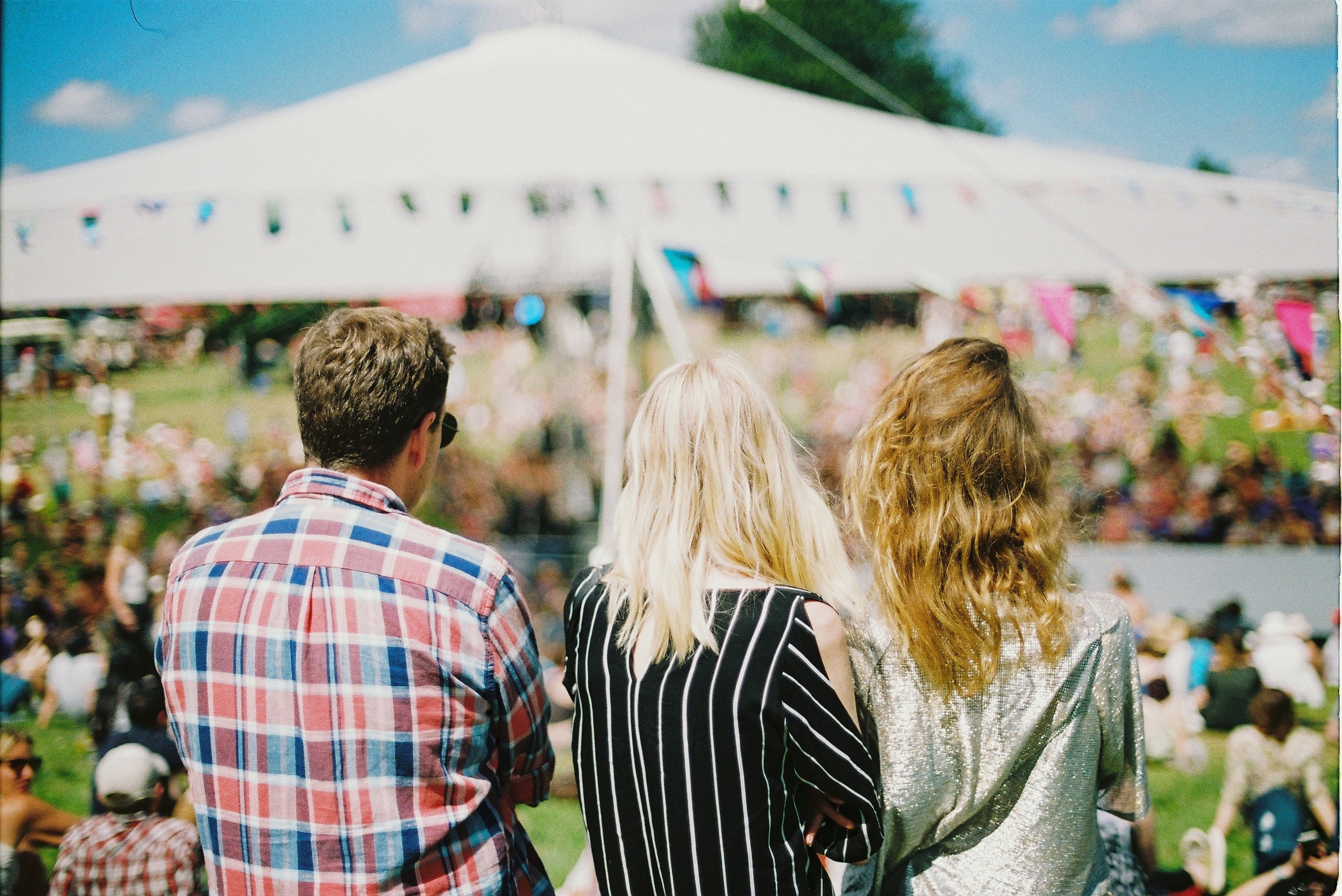 One man and two women at a festival.