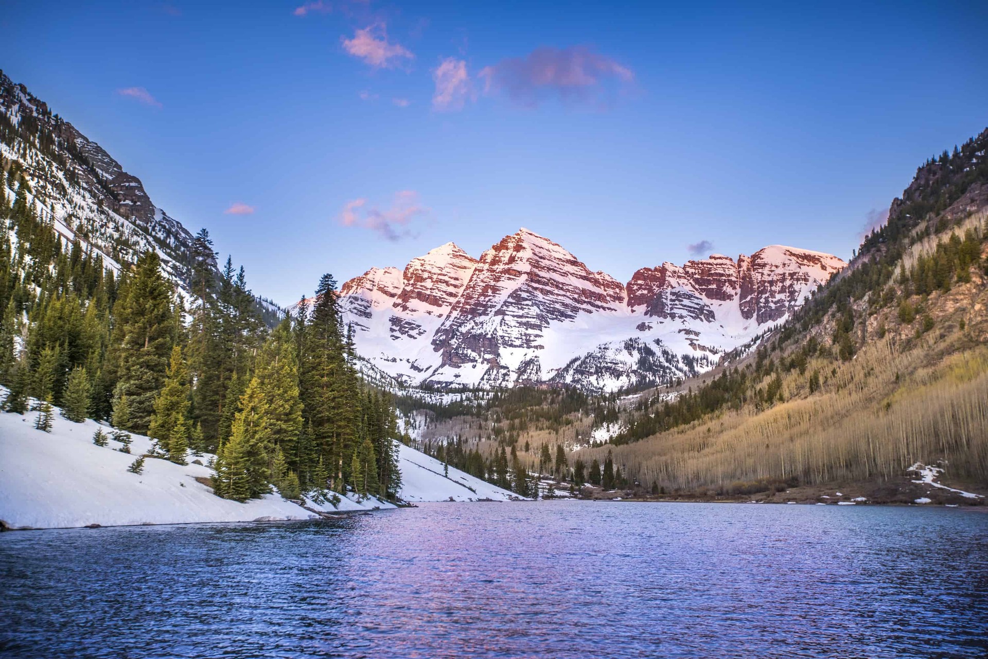Lake in Colorado surrounded by snowy mountain peaks
