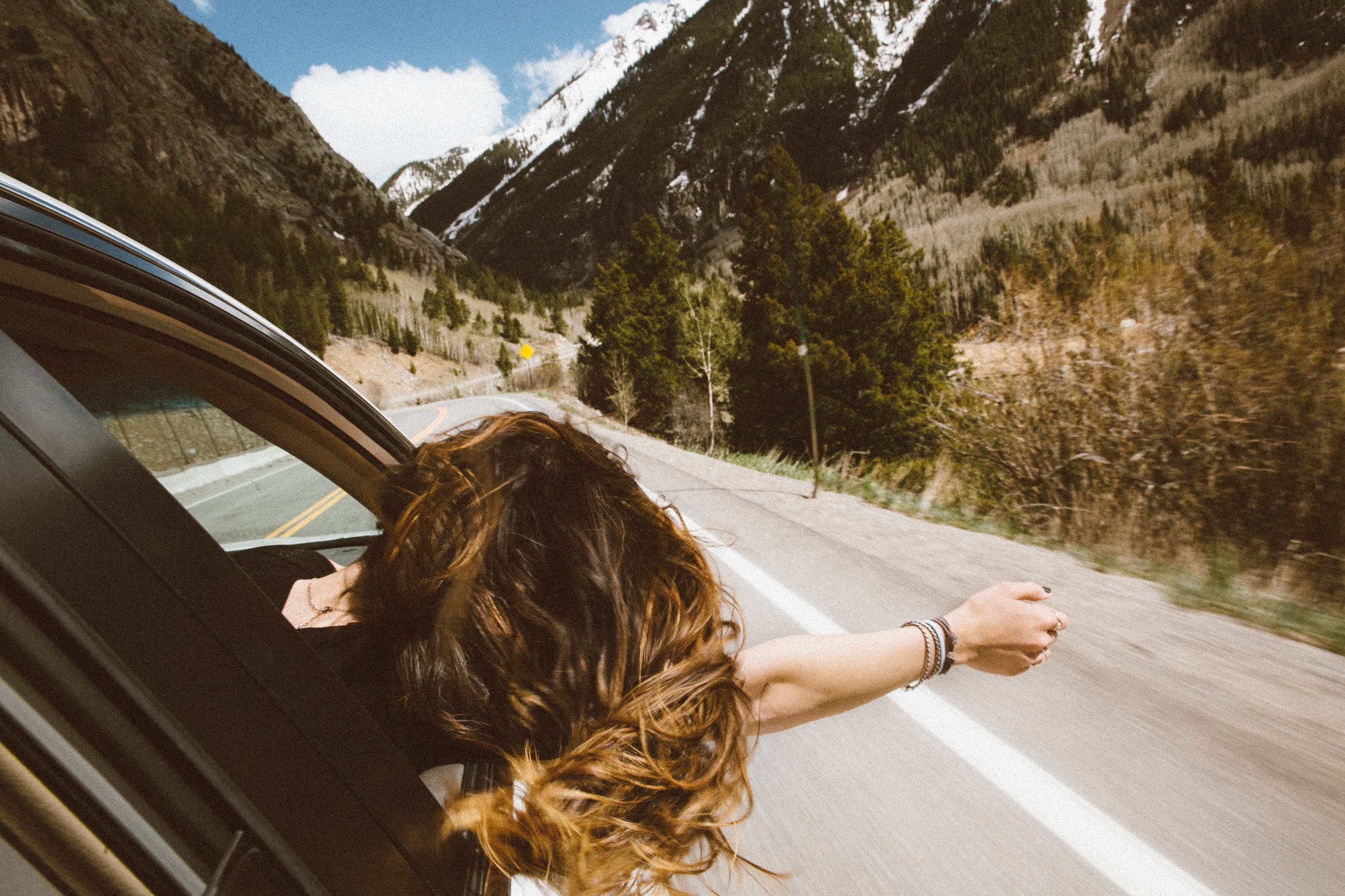 Woman on a drive experiencing fresh air.