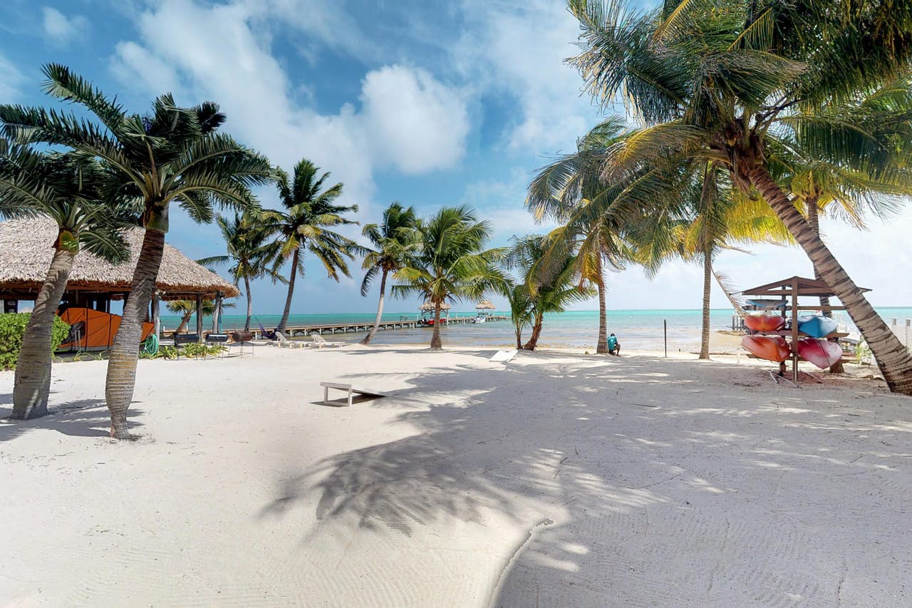 Beach in Belize with dock and kayaks