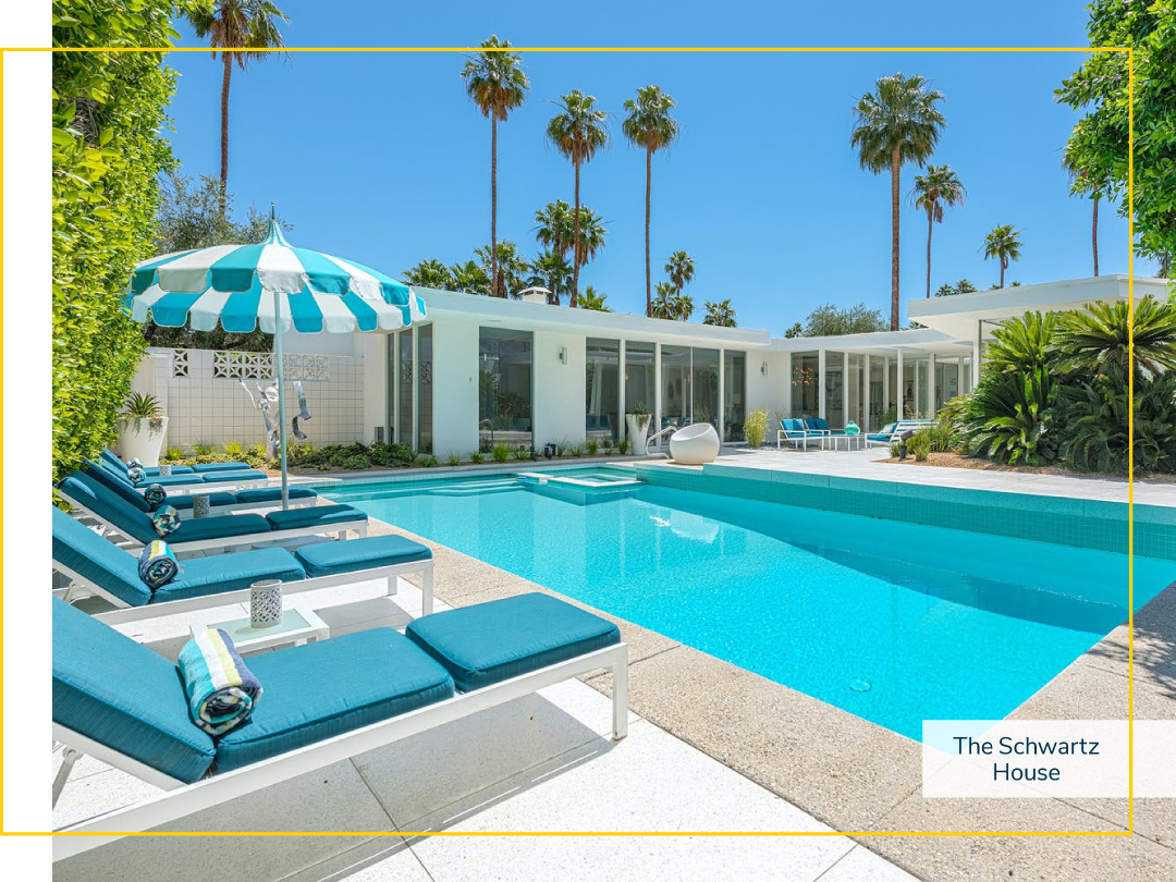 Vacation home with an outdoor pool filled with clear blue water and pool lounge chairs on a sunny day.