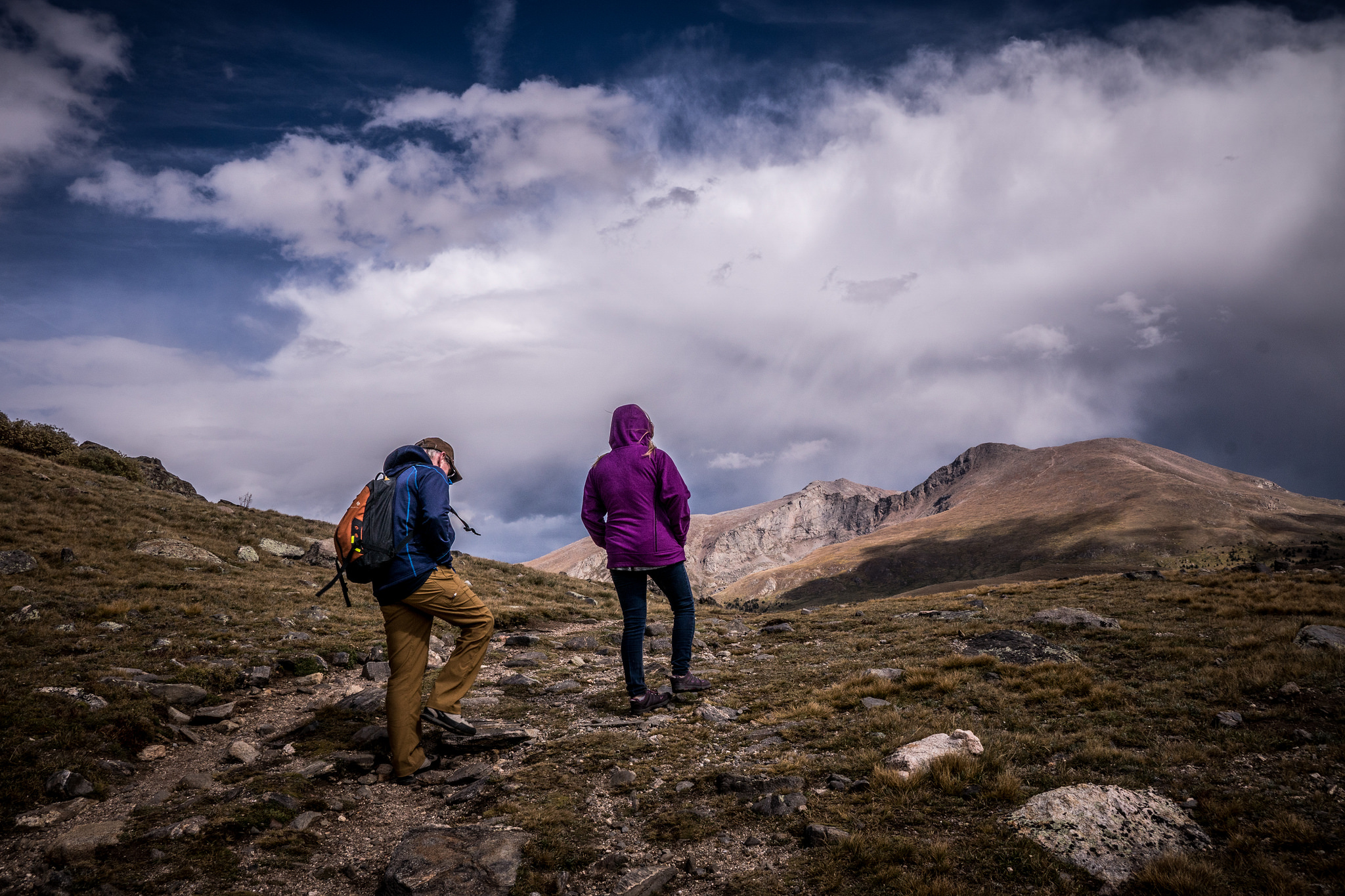 two hikers making their way up to a peak in colorado