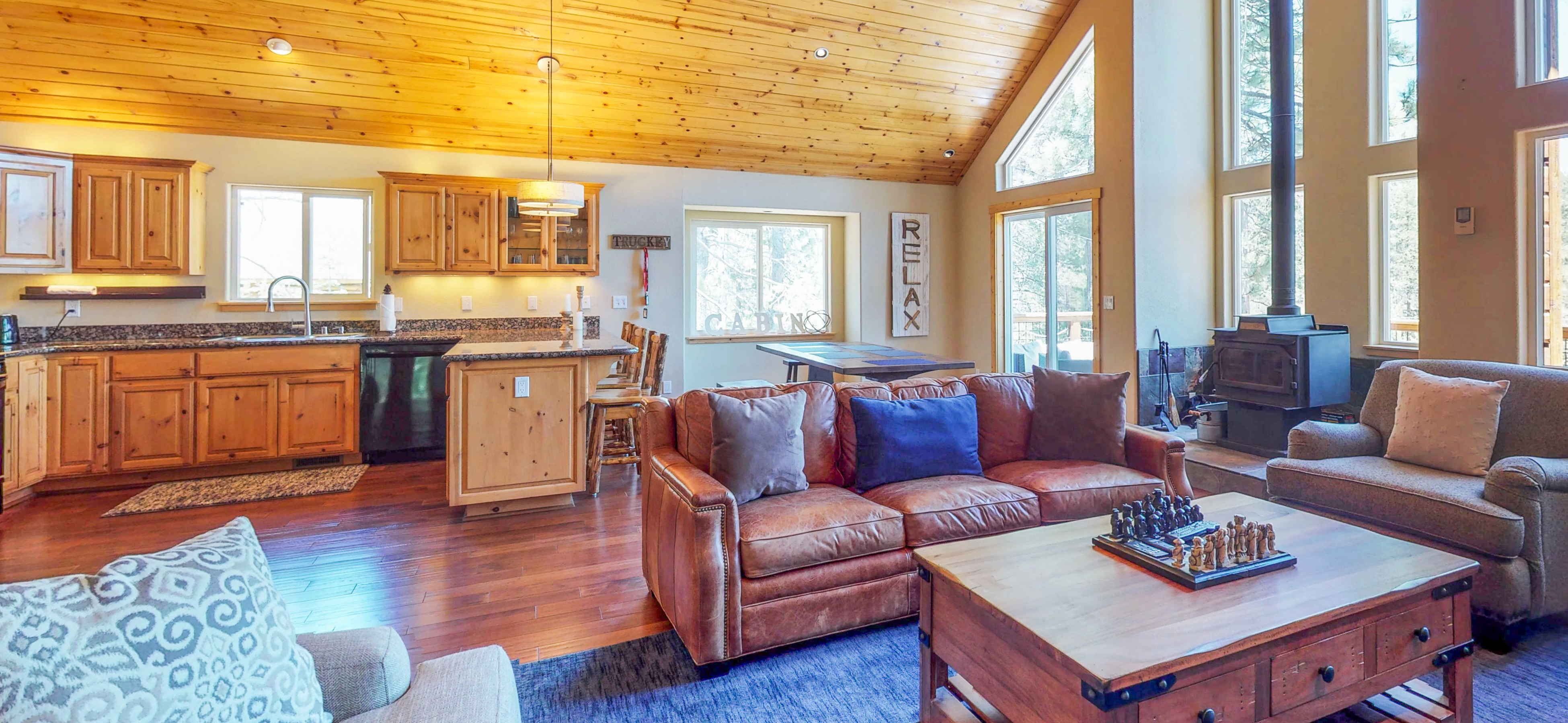 Open layout of large cabin with wood panels and a leather couch in Truckee, CA