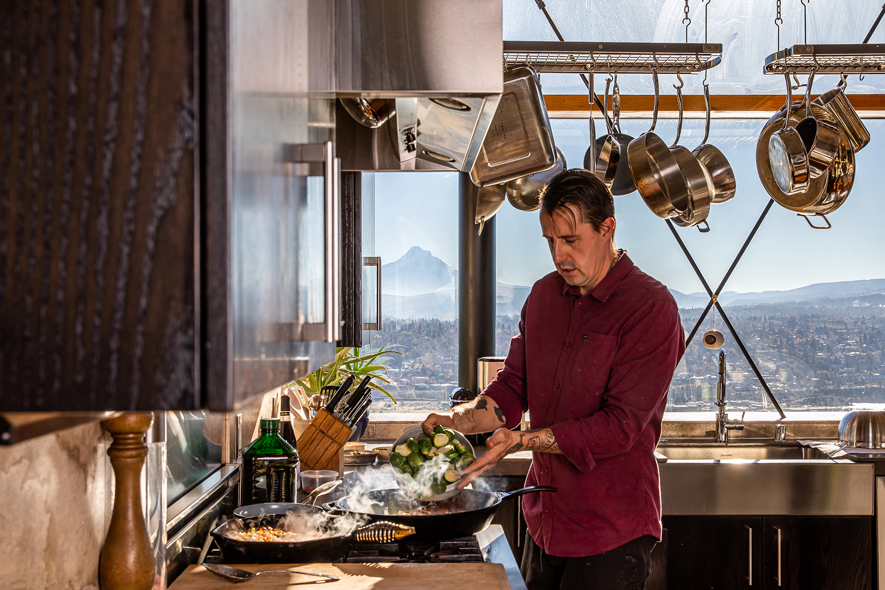chef gabriel cooks brussels in a cast iron pot on the stove with mount hood in the distance