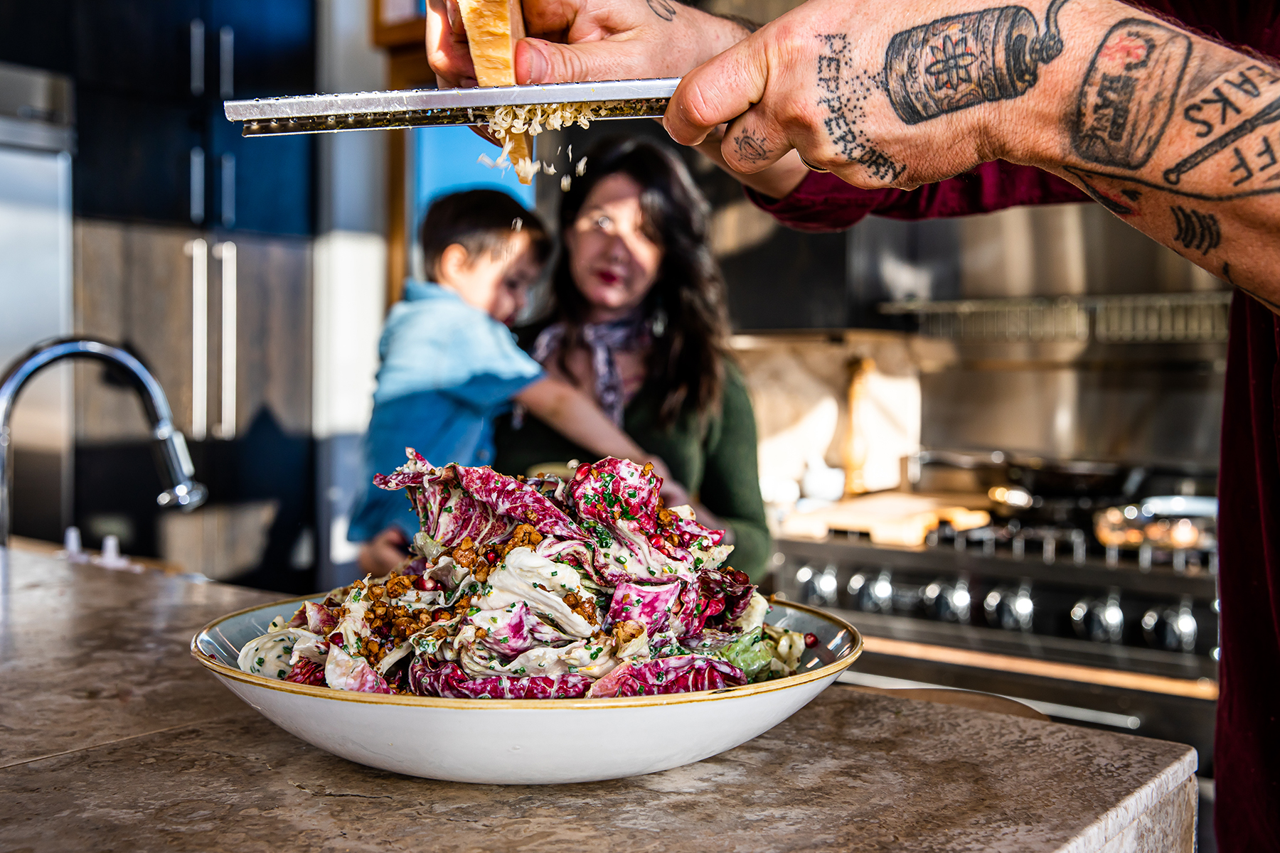 chef gabriel grates cheese over his radicchio salad