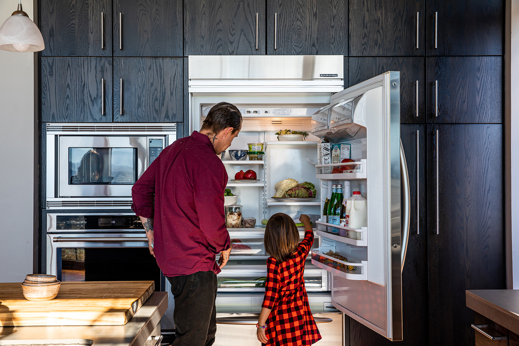 chef gabriel and his daughter take stock of the fridge of their vacation rental