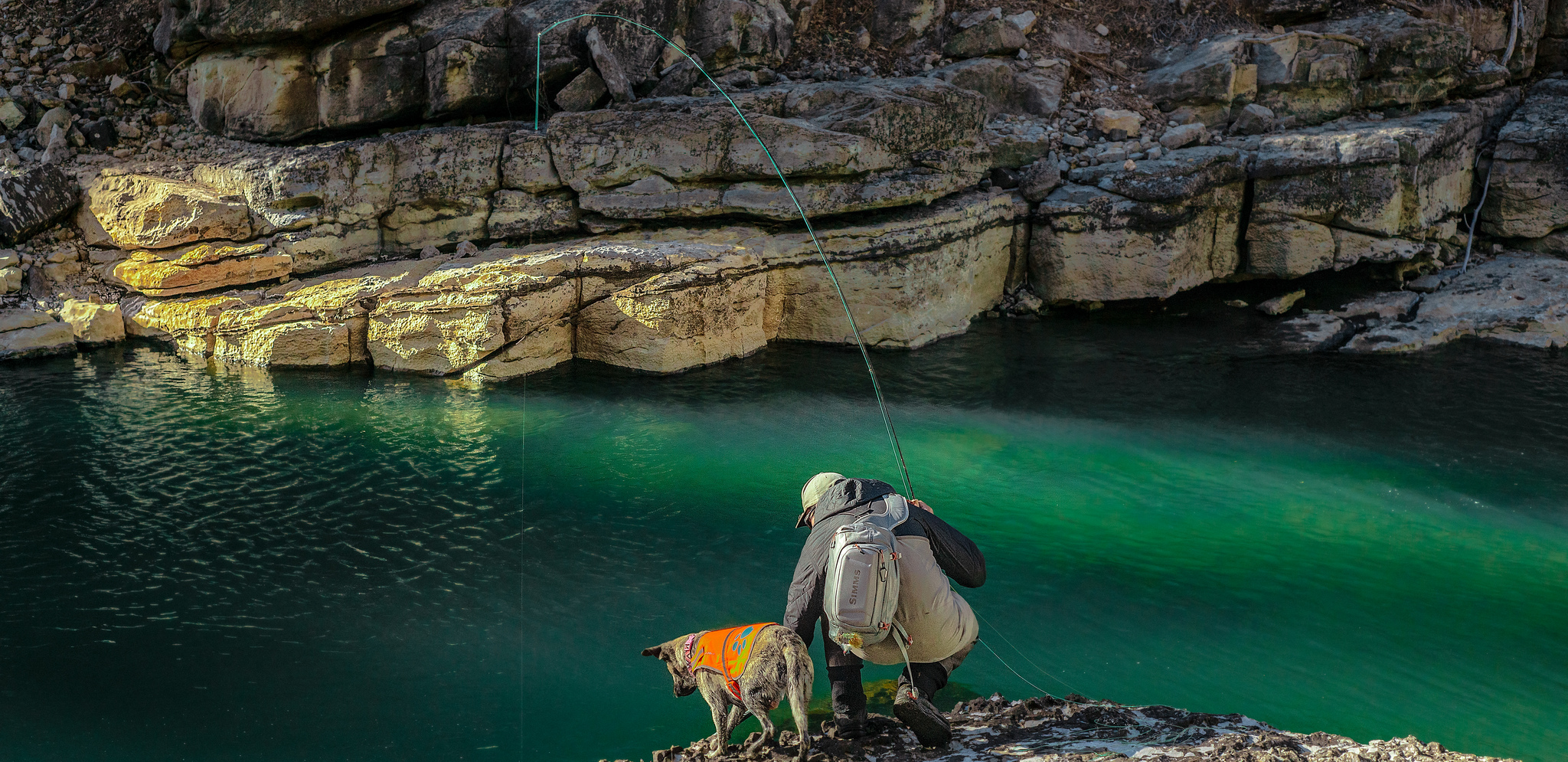 A fisherman and his dog near Piedra River Hot Springs in Colorado