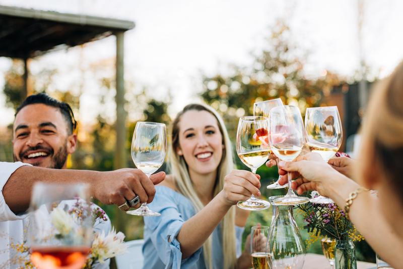 Image of people clanking wine glasses at a wedding.