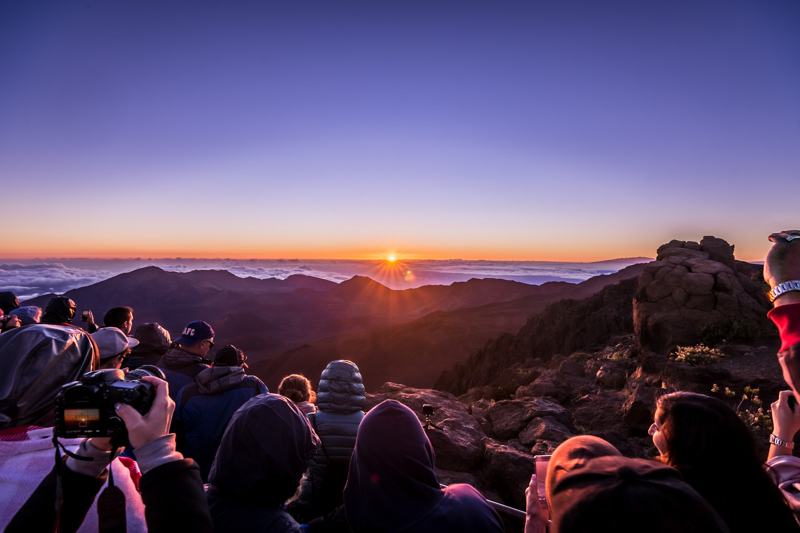 a group of people seeing the sun rise at haleakala