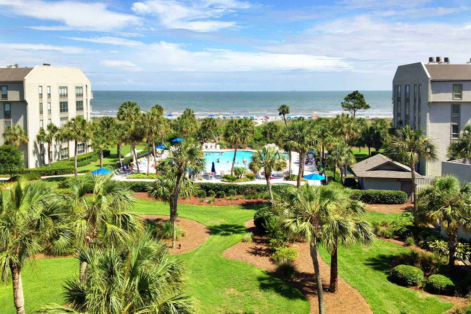 Resort with palm trees and outdoor pool near a beach in Hilton Head