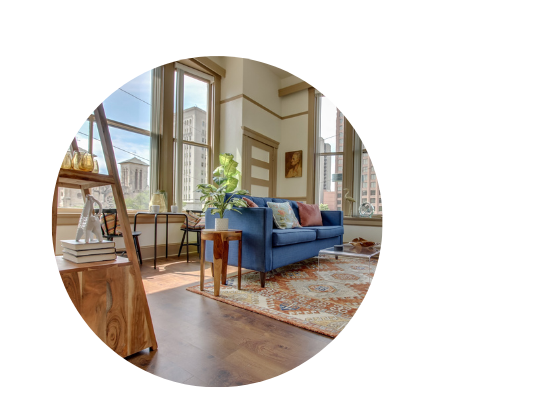 vacation rental with blue couch, a live plant and large windows