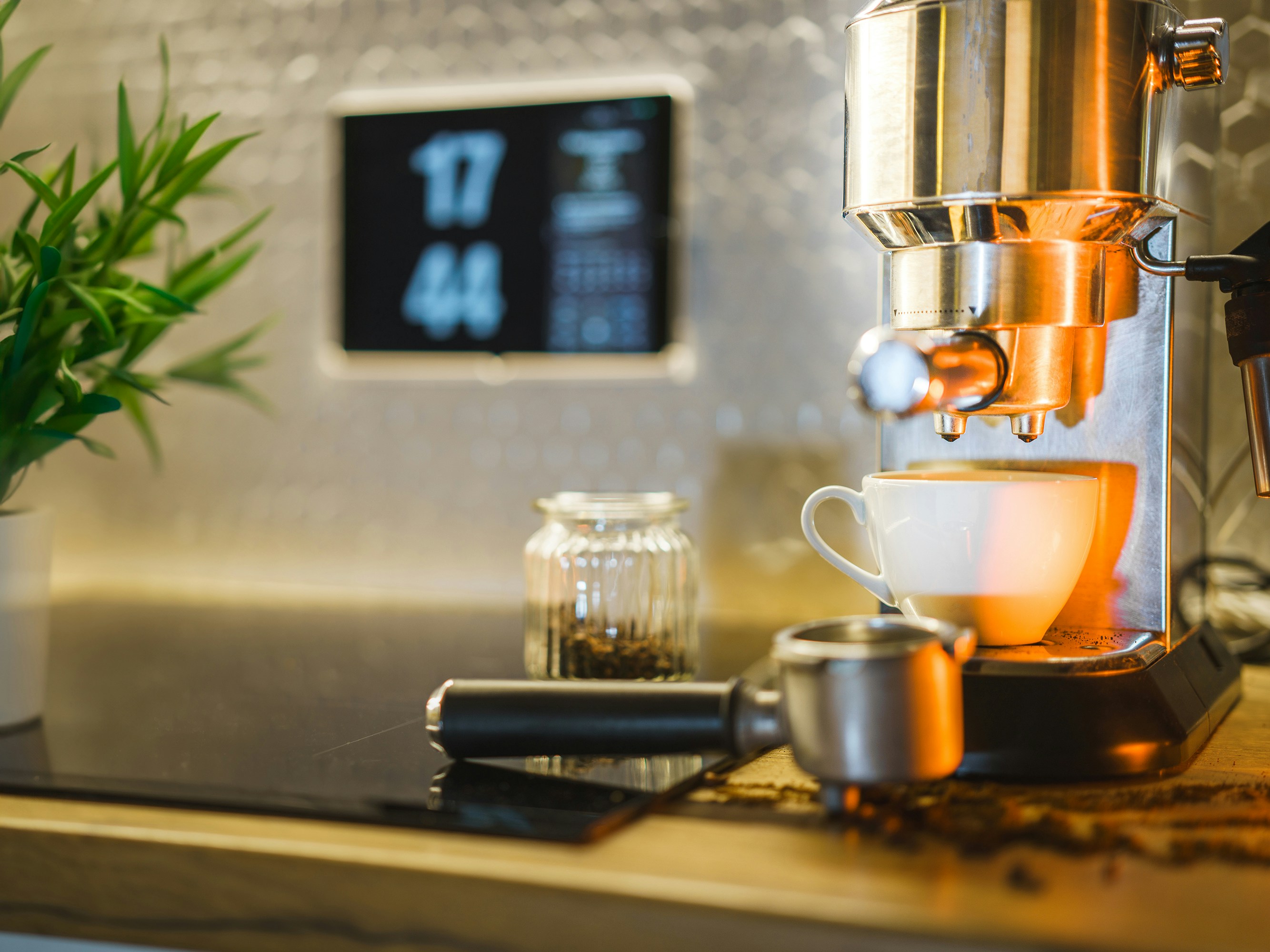 Home kitchen. Coffee cup next to espresso machine. Smart home display.