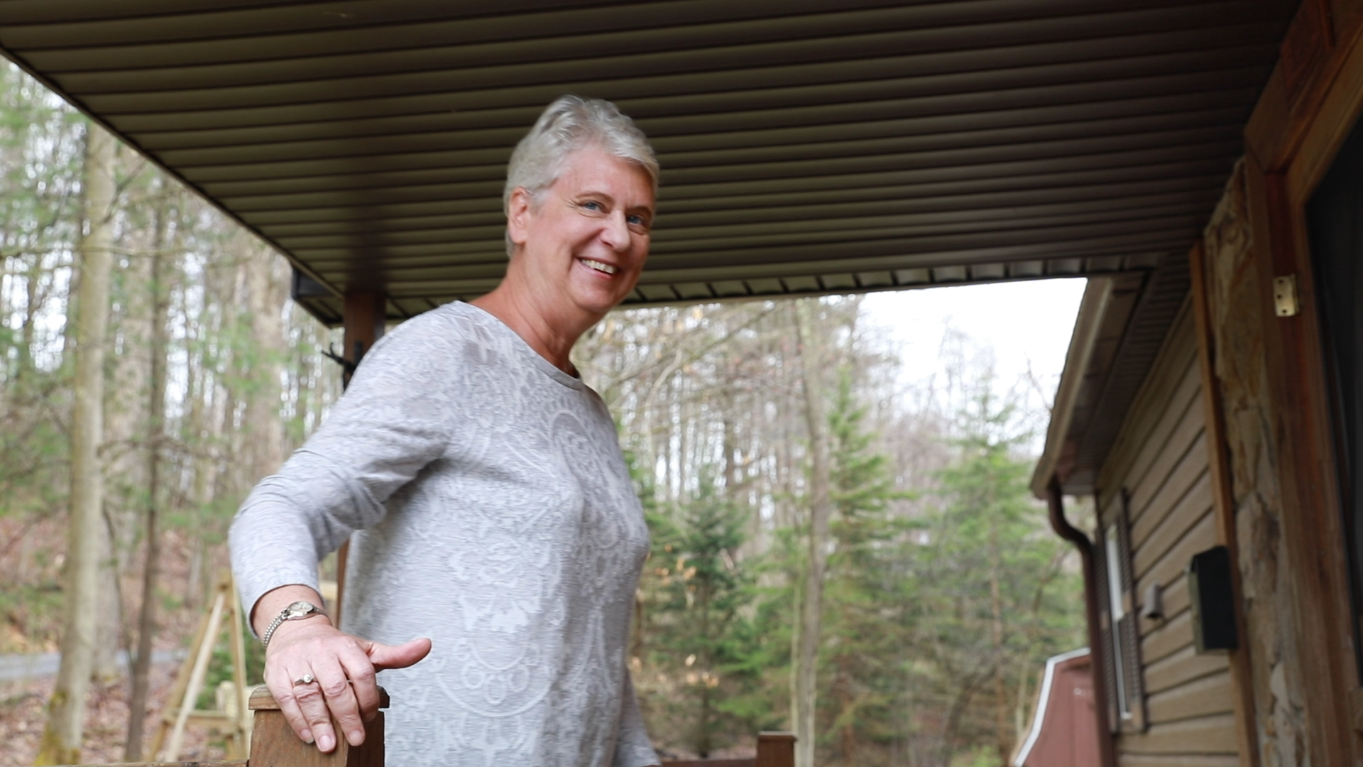 Vacasa homeowner Karen smiles outside of her vacation home