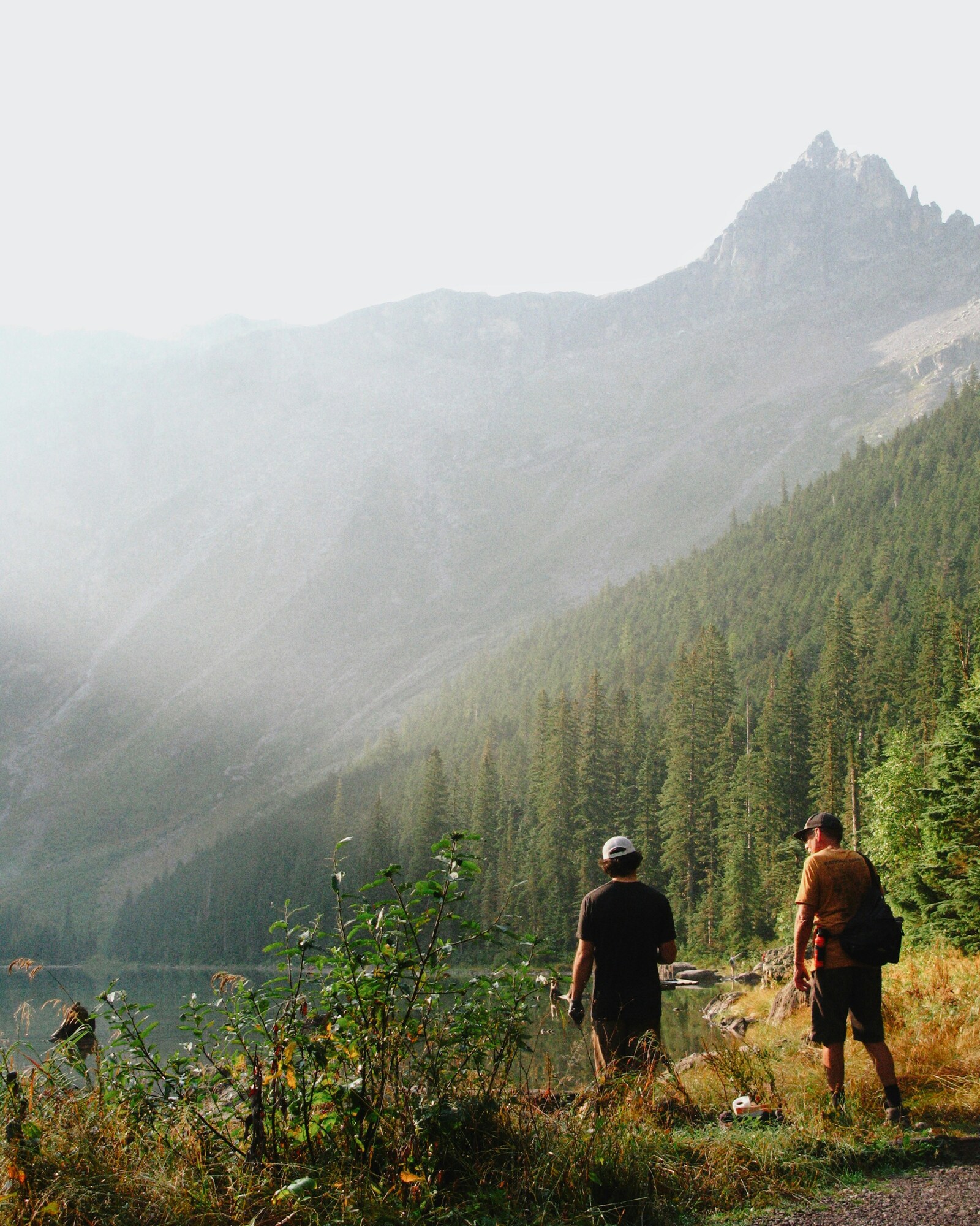 two hikers looking at a lake in Glacier National Park