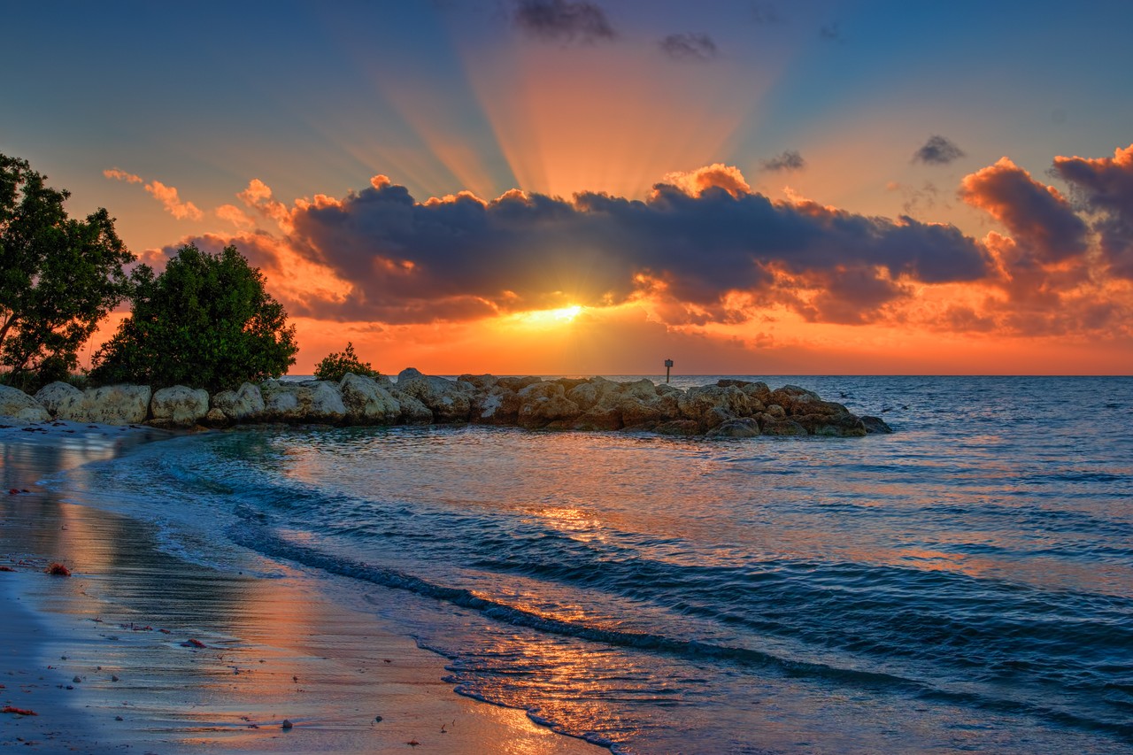 Beautiful orange sunset peeking through clouds in Key West, FL