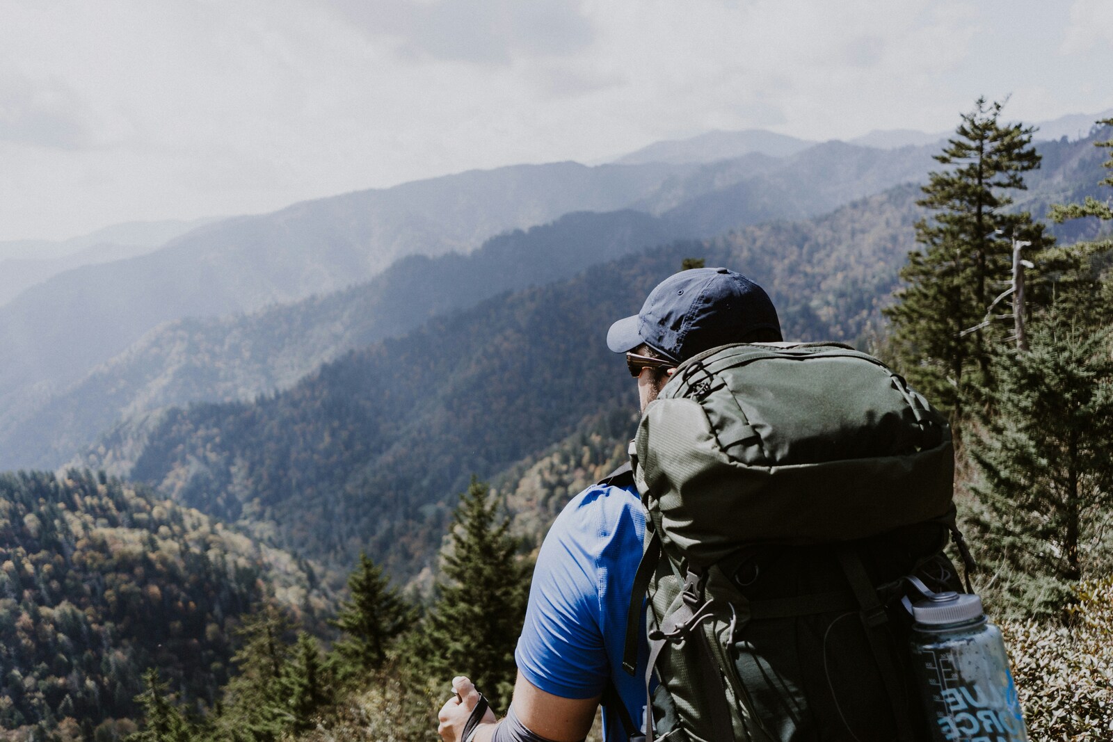 man standing on top of a mountain ridge overlooking Smoky Mountains national park