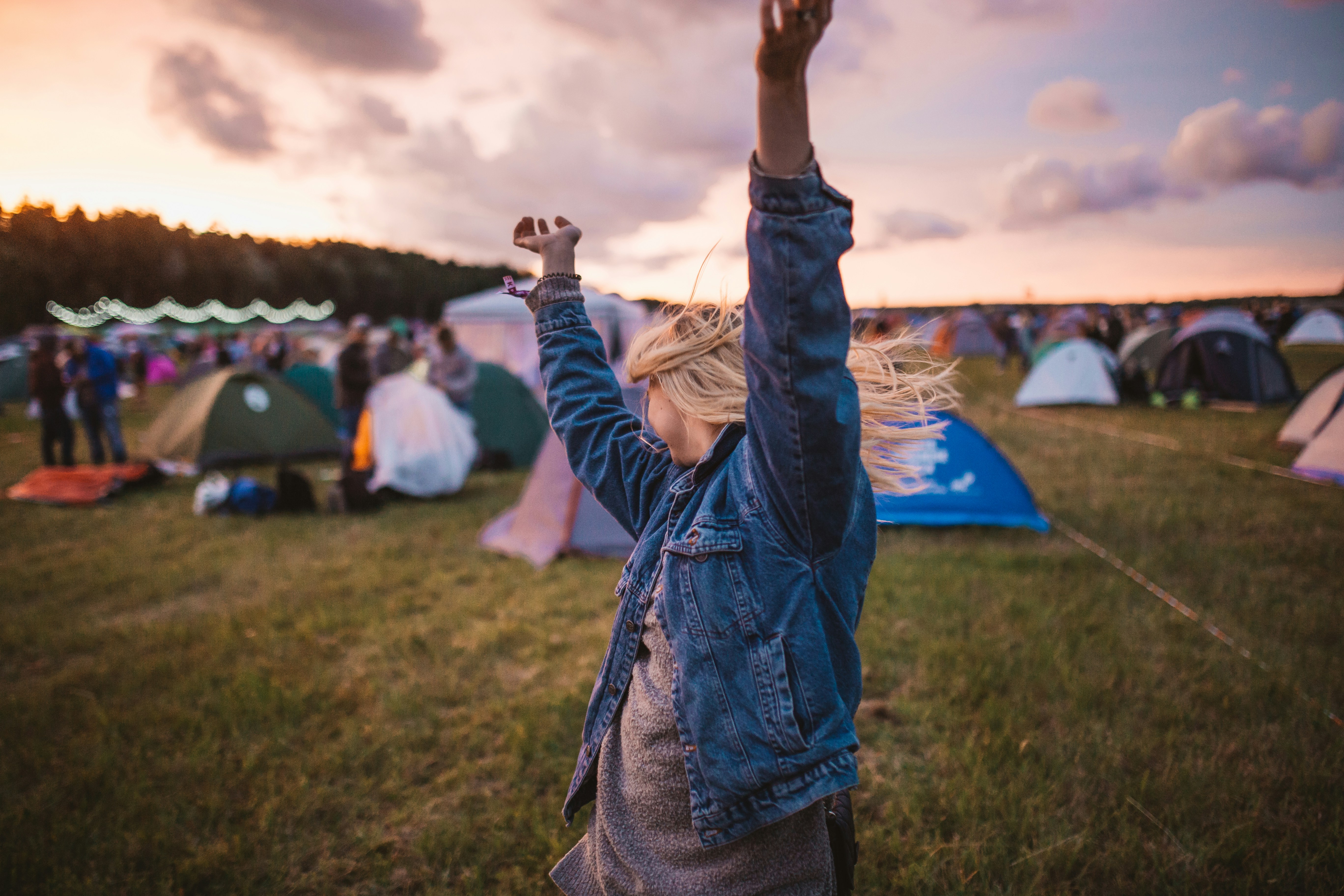 Woman dancing in front of tests at a music festival.