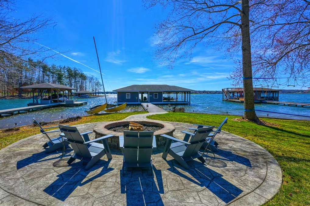 a firepit and adirondack chairs overlooking lake anna in the fall on a sunny day