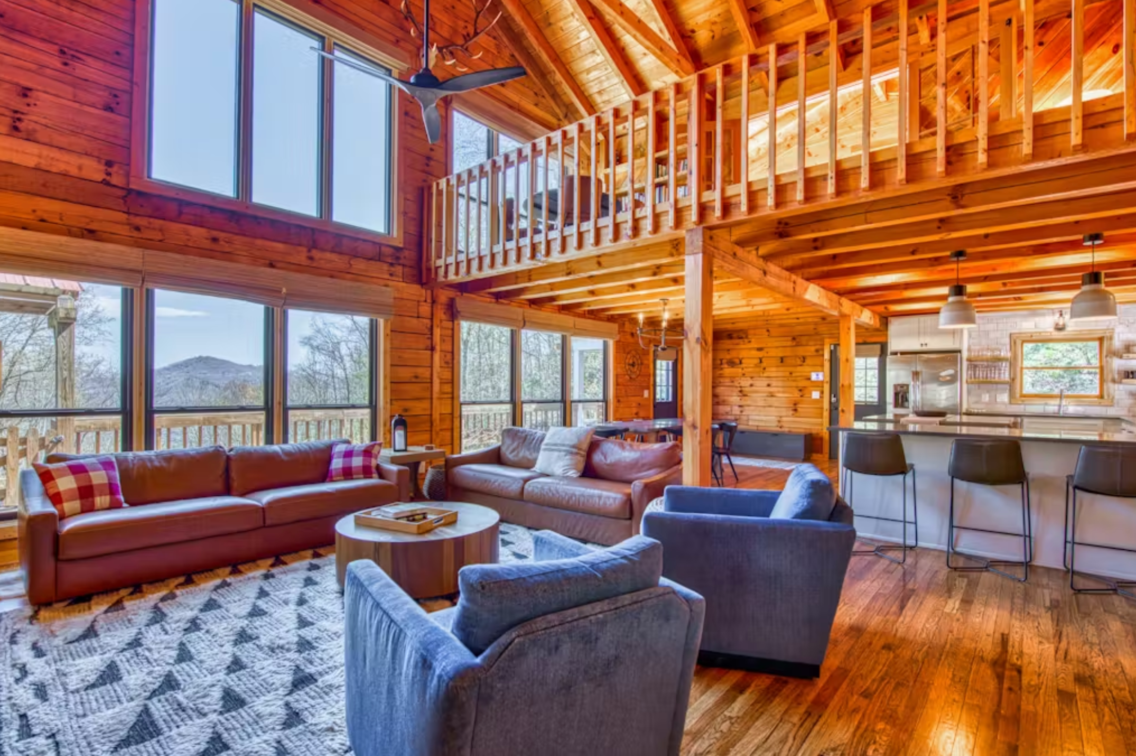 View of the living room with sofa and lounge chairs with a view of the Smoky Mountains