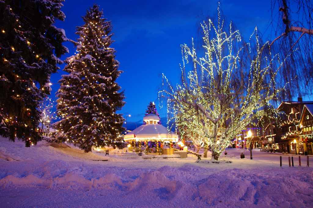 Winter in Leavenworth, WA with snow covered streets and Christmas trees with lights.