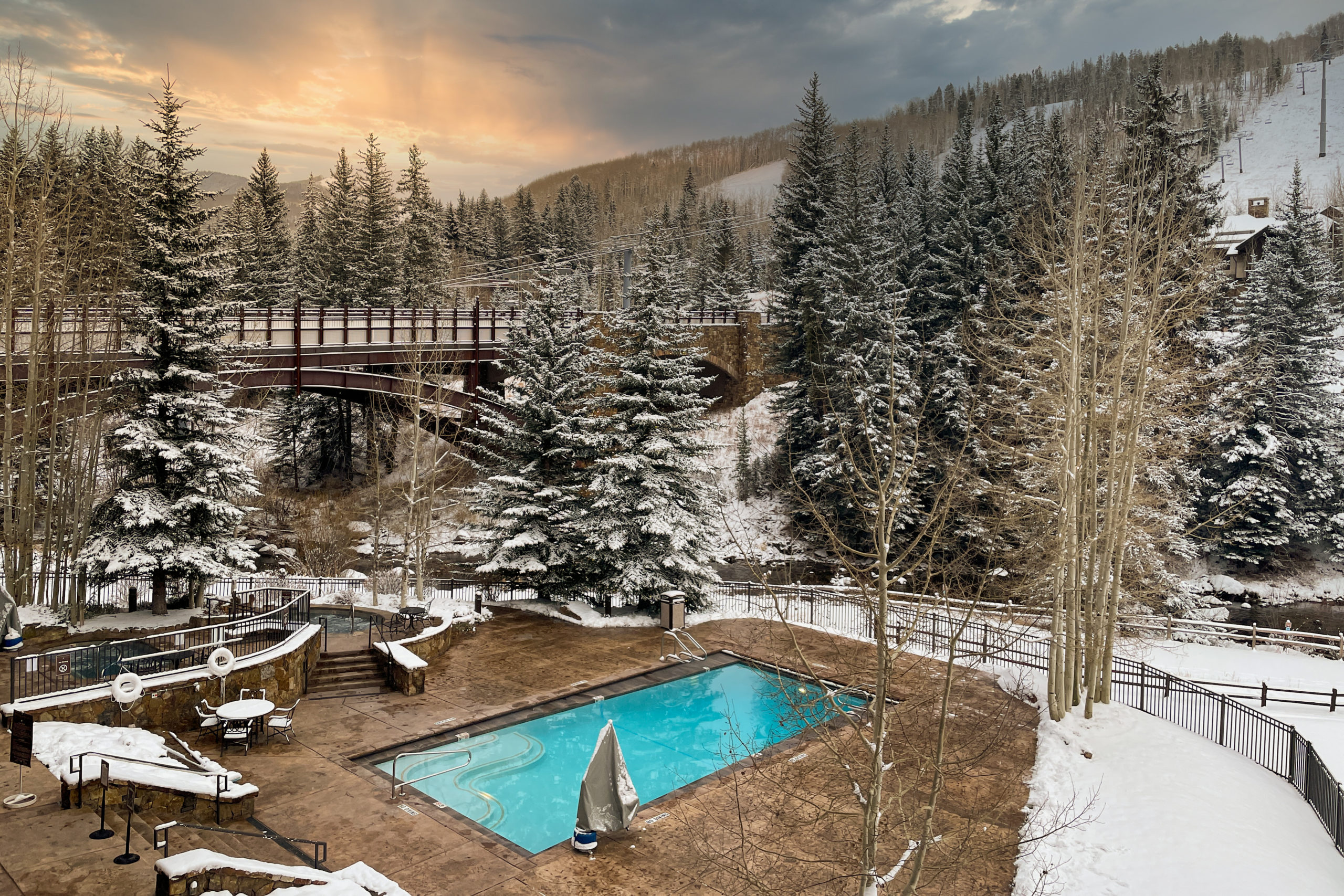 Outdoor pool of Lion Square Lodge surrounded by snow covered pine trees