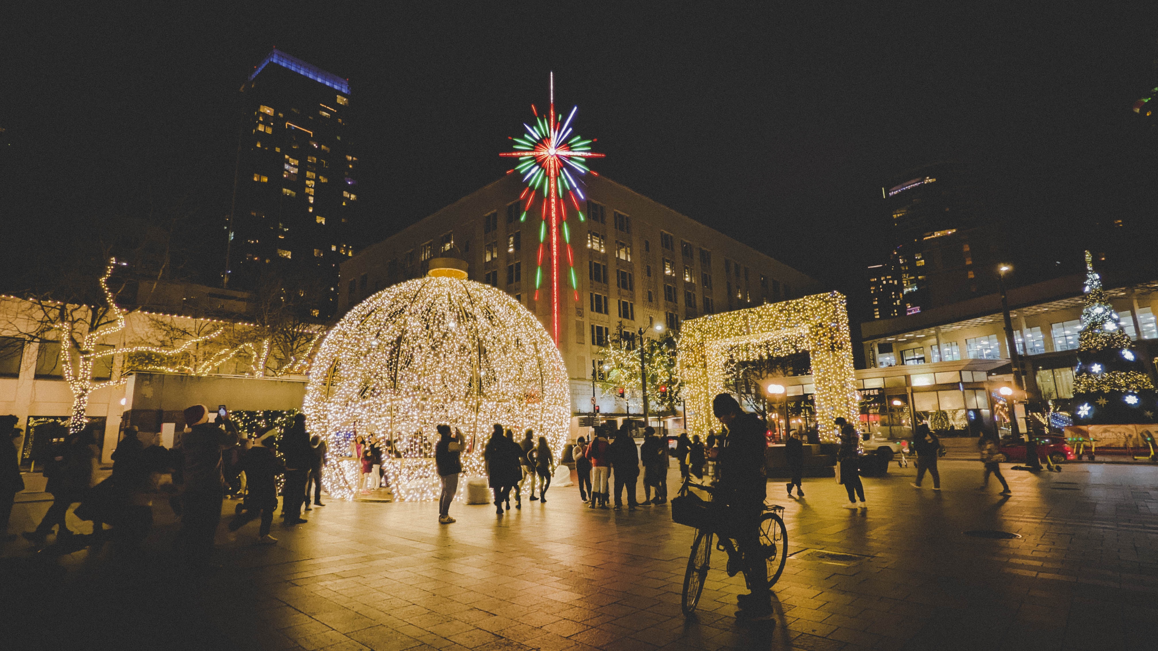 A group of people standing around a Christmas light display.