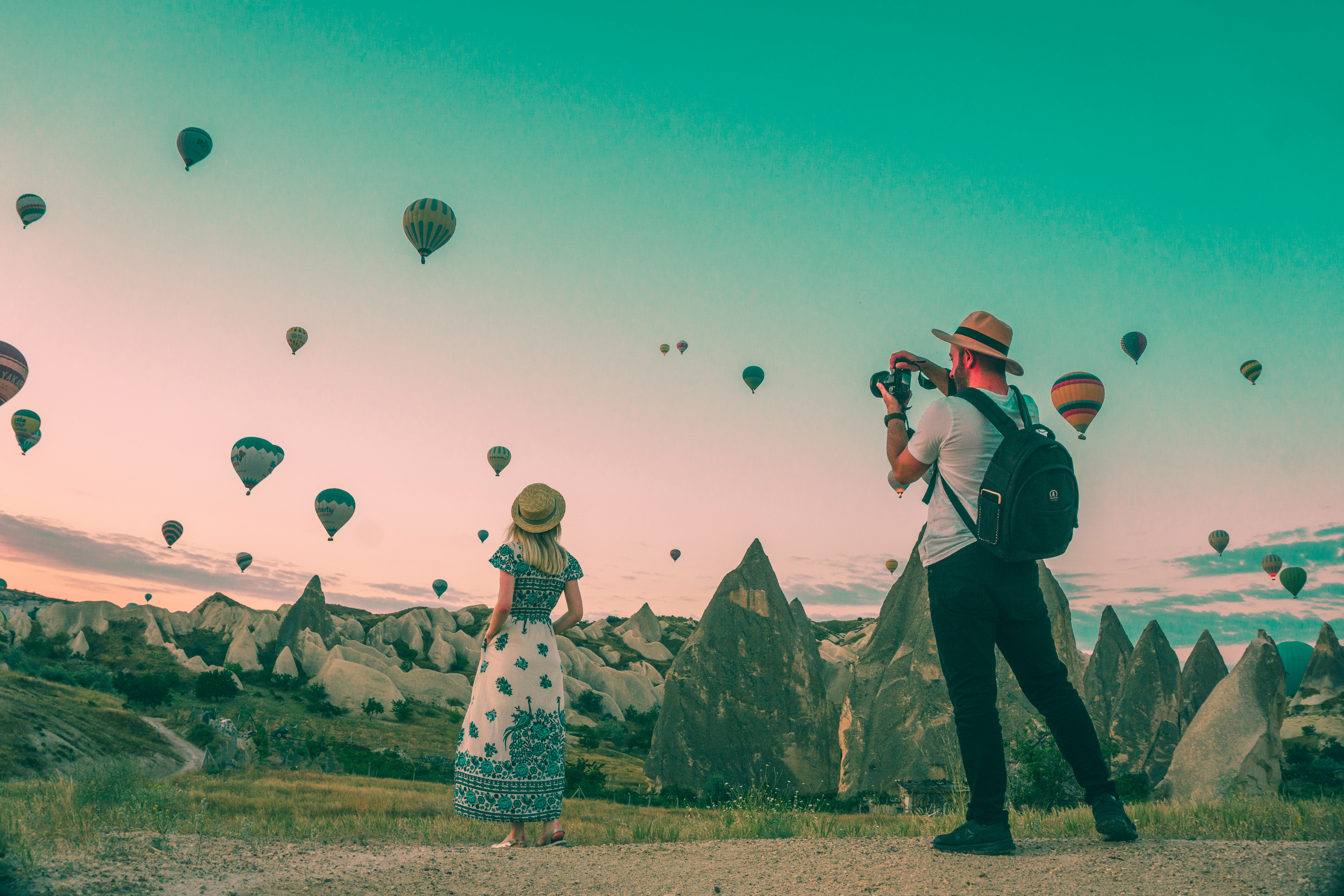 Man taking a photo of the balloon festival in New Mexico alongside a woman in a dress.