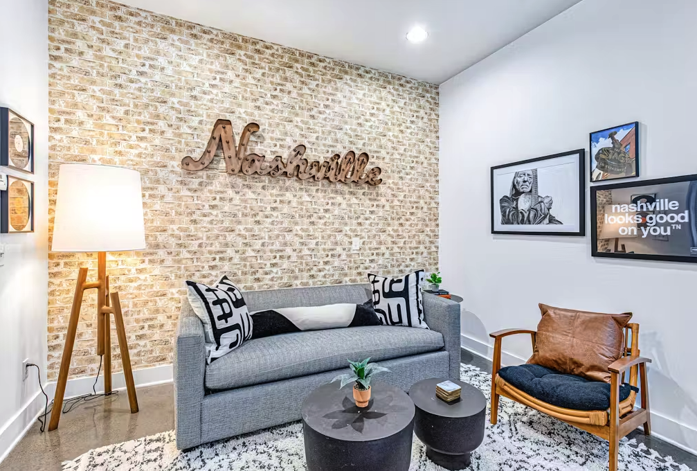 living space of apartment rental in nashville with brick wall and "nashville" sign on wall
