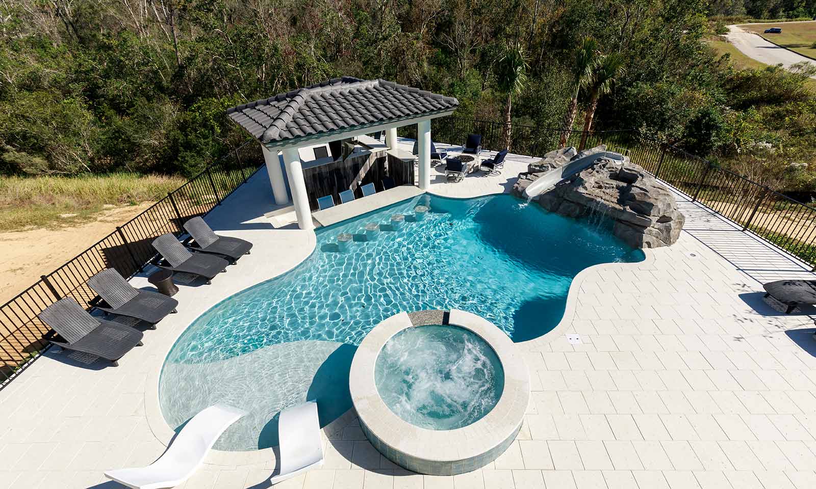 The pool area with a jacuzzi as seen from a drone shot at a vacation rental in Florida.