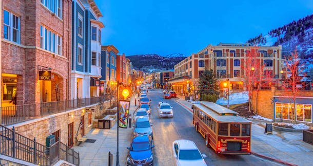 Busy street with cars in Park City and snow in the mountains