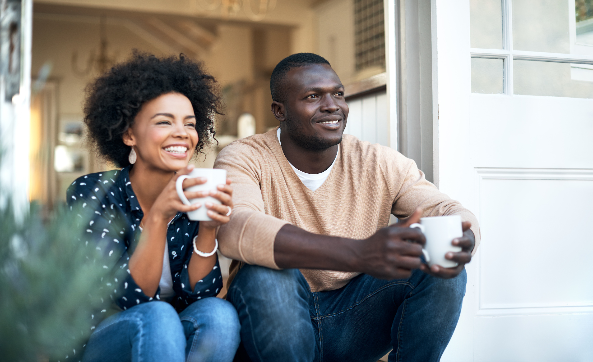 a couple enjoying coffee on their porch