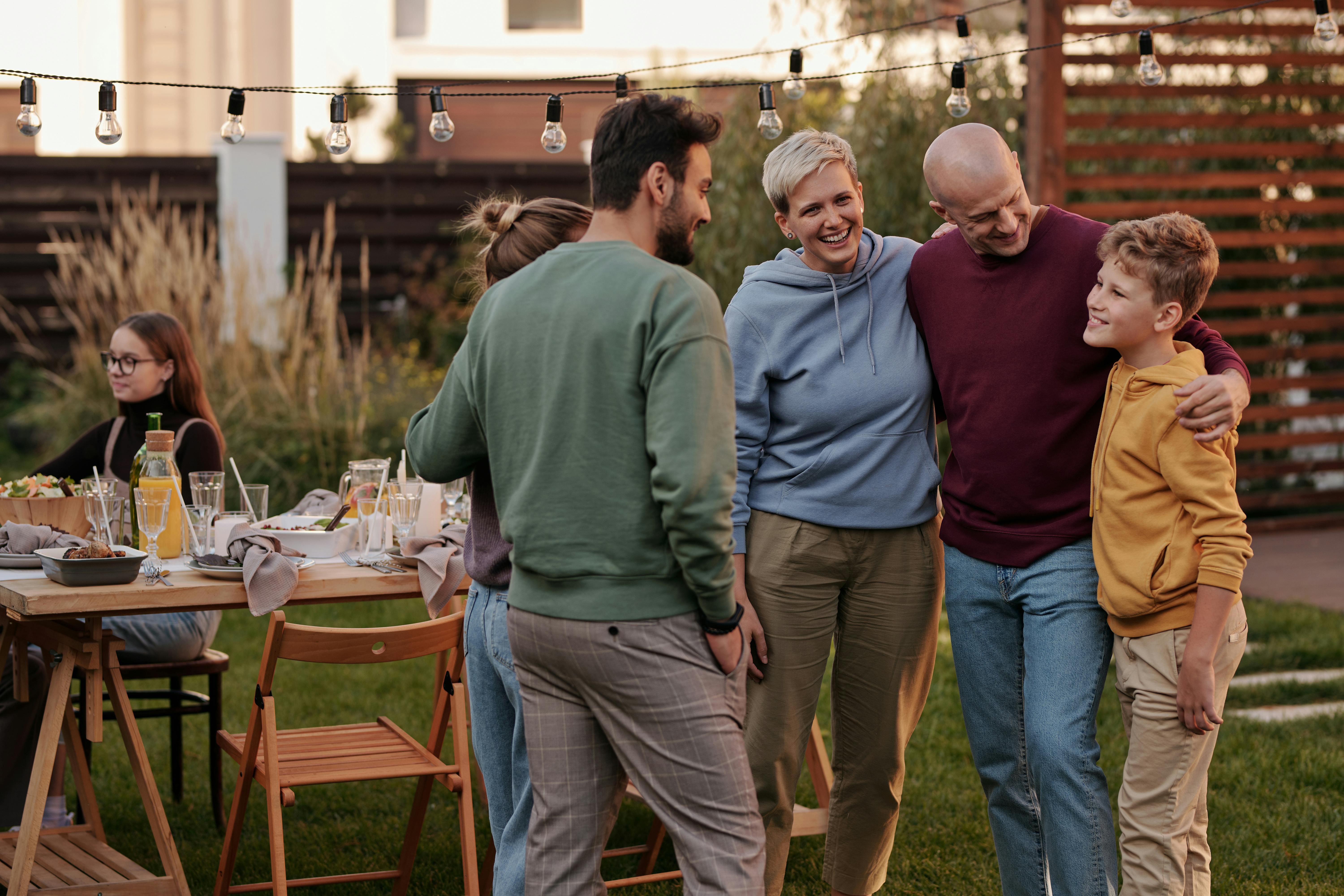 A family hanging out outside at a picnic table.